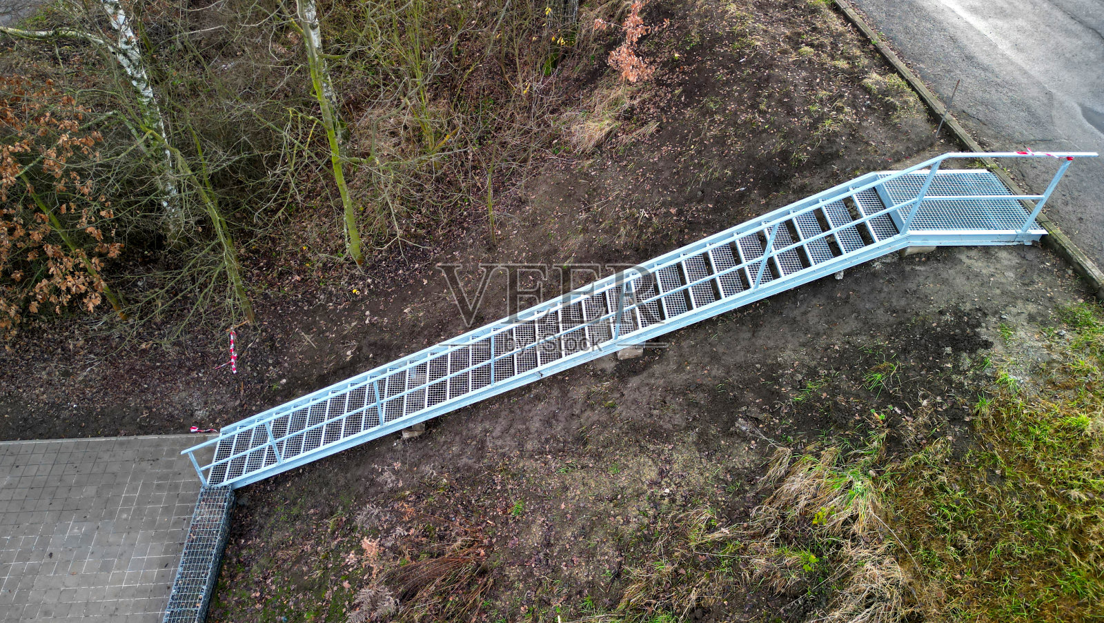 工业大厅、仓库有侧门在陡峭的楼梯上，即使在重载下也有高阻力镀锌钢地板格栅和栏杆。膨胀金属，长梯子楼梯，栏杆，道路照片摄影图片