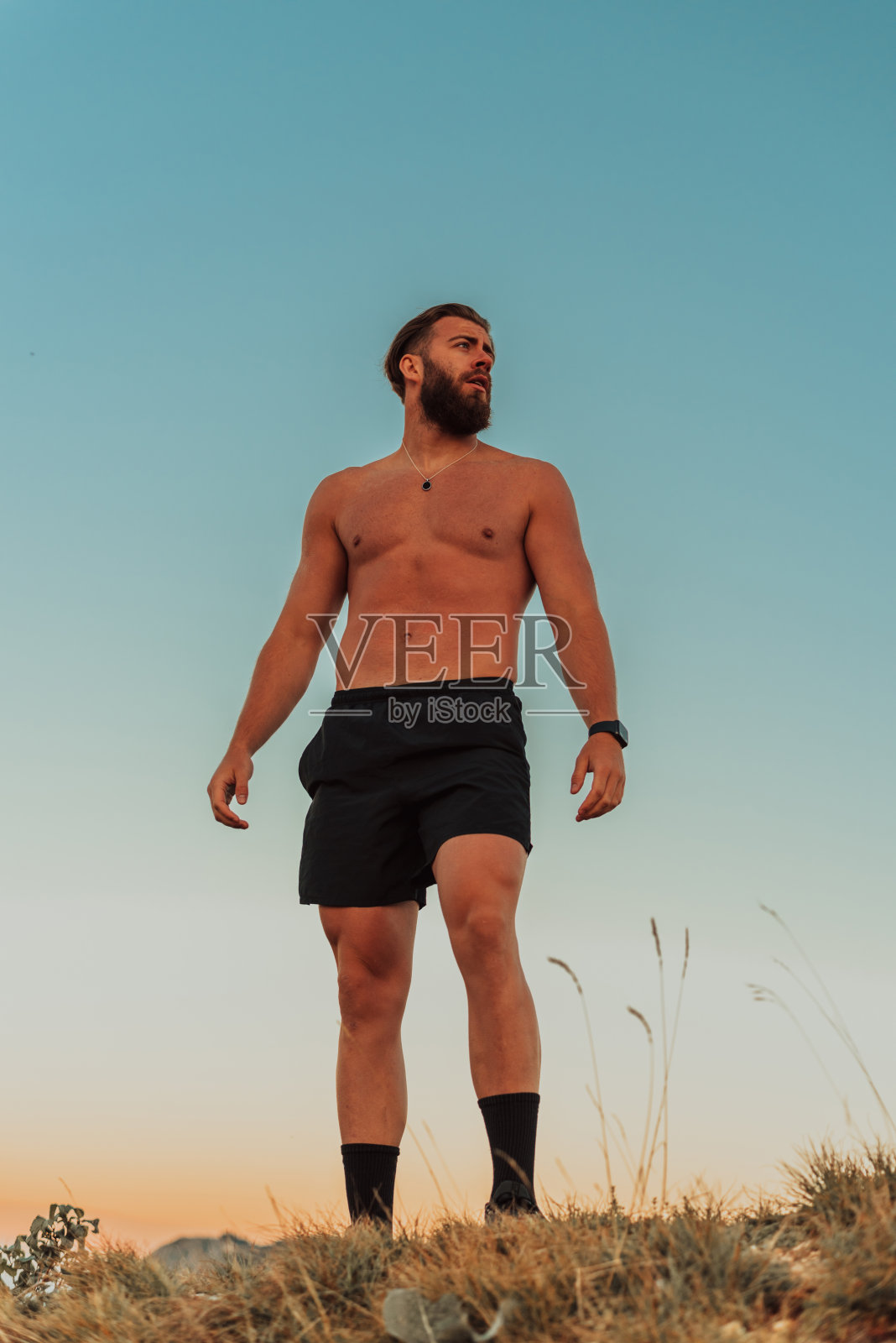 日出时分，一名意志坚定的运动员在山顶准备开始训练照片摄影图片