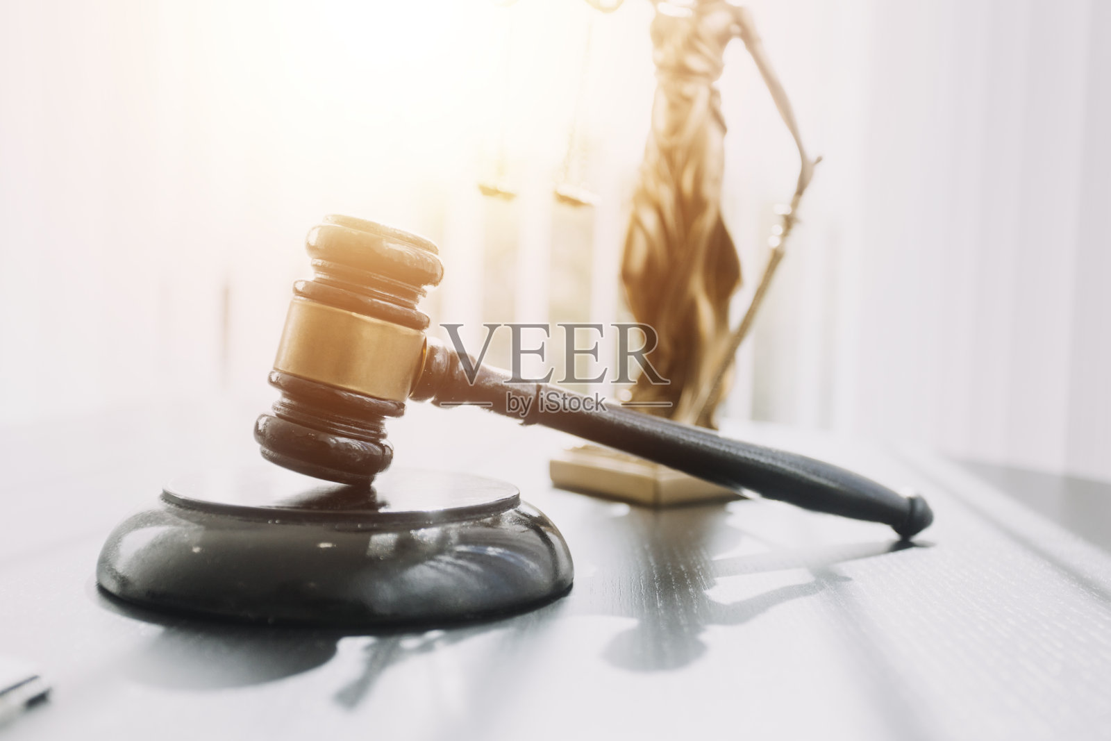 正义与法律观念。在现代化的办公室里，男性法官在法庭上，与文件法律书籍一起，在桌子上报告案件。照片摄影图片