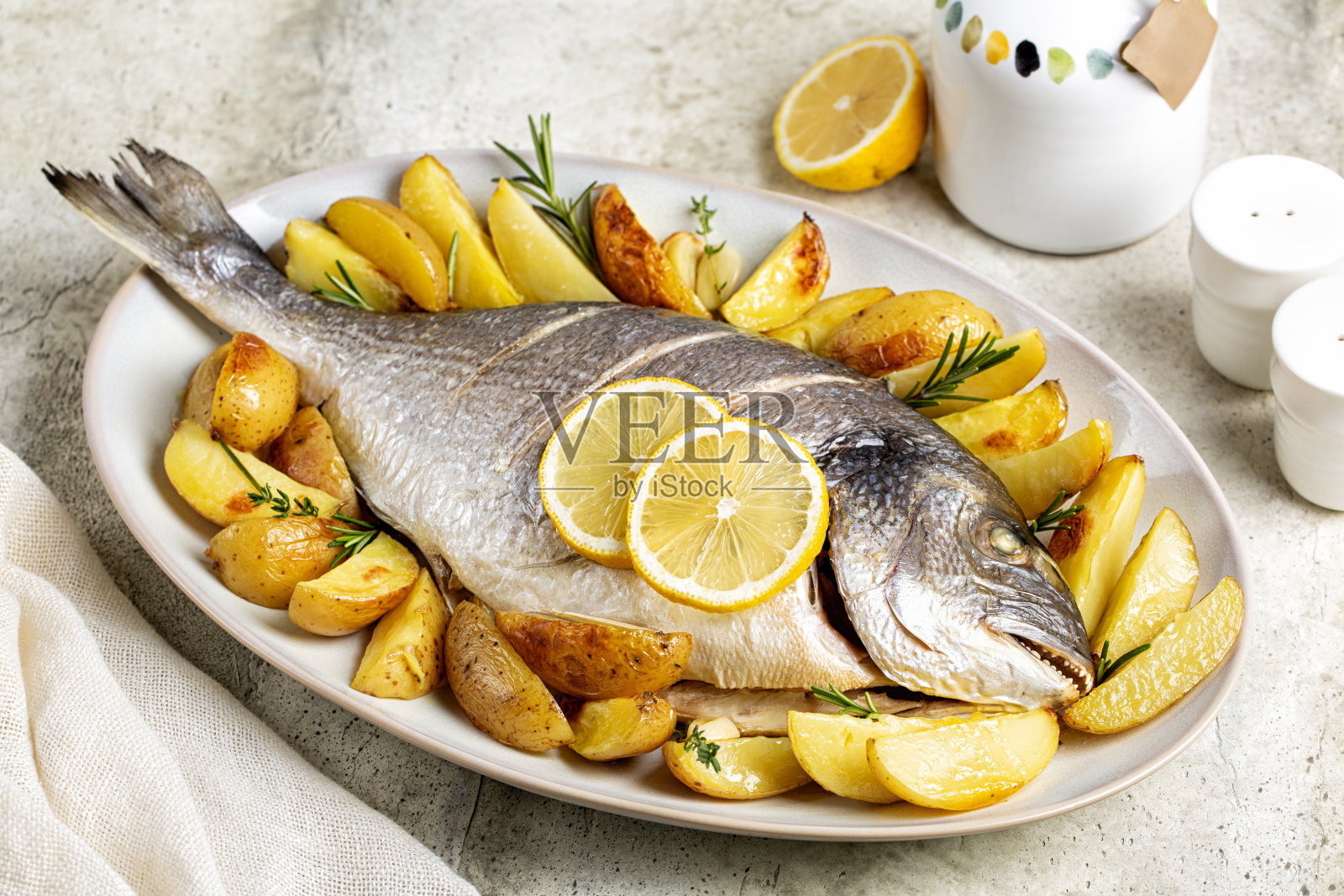 烤鲷鱼配土豆、柠檬和香草照片摄影图片