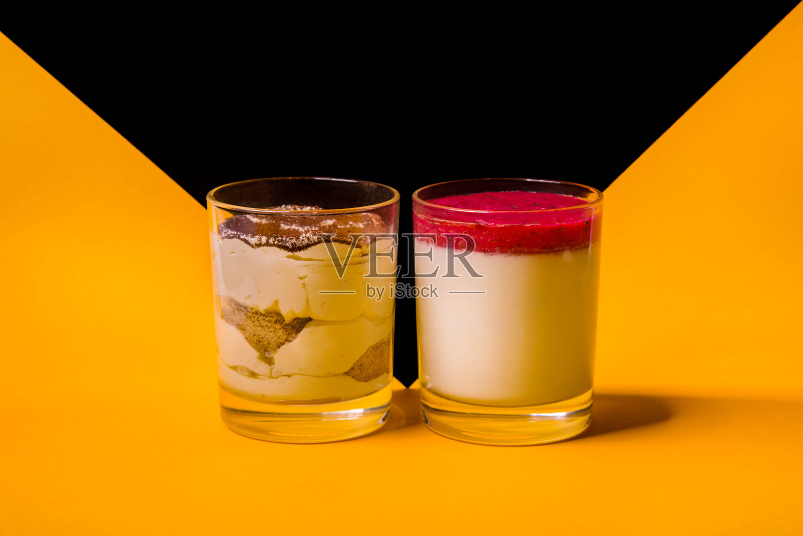 意式奶冻配草莓酱，提拉米苏配可可，黄黑底色。水平方向照片摄影图片