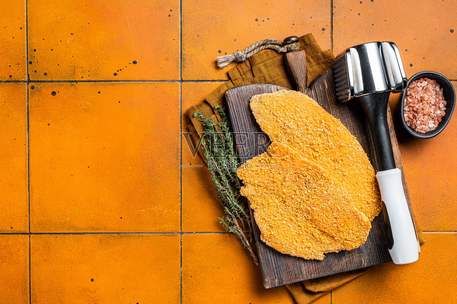 生香肠炸肉排，裹上面包屑的肉排。橙色背景。前视图。本空间照片摄影图片