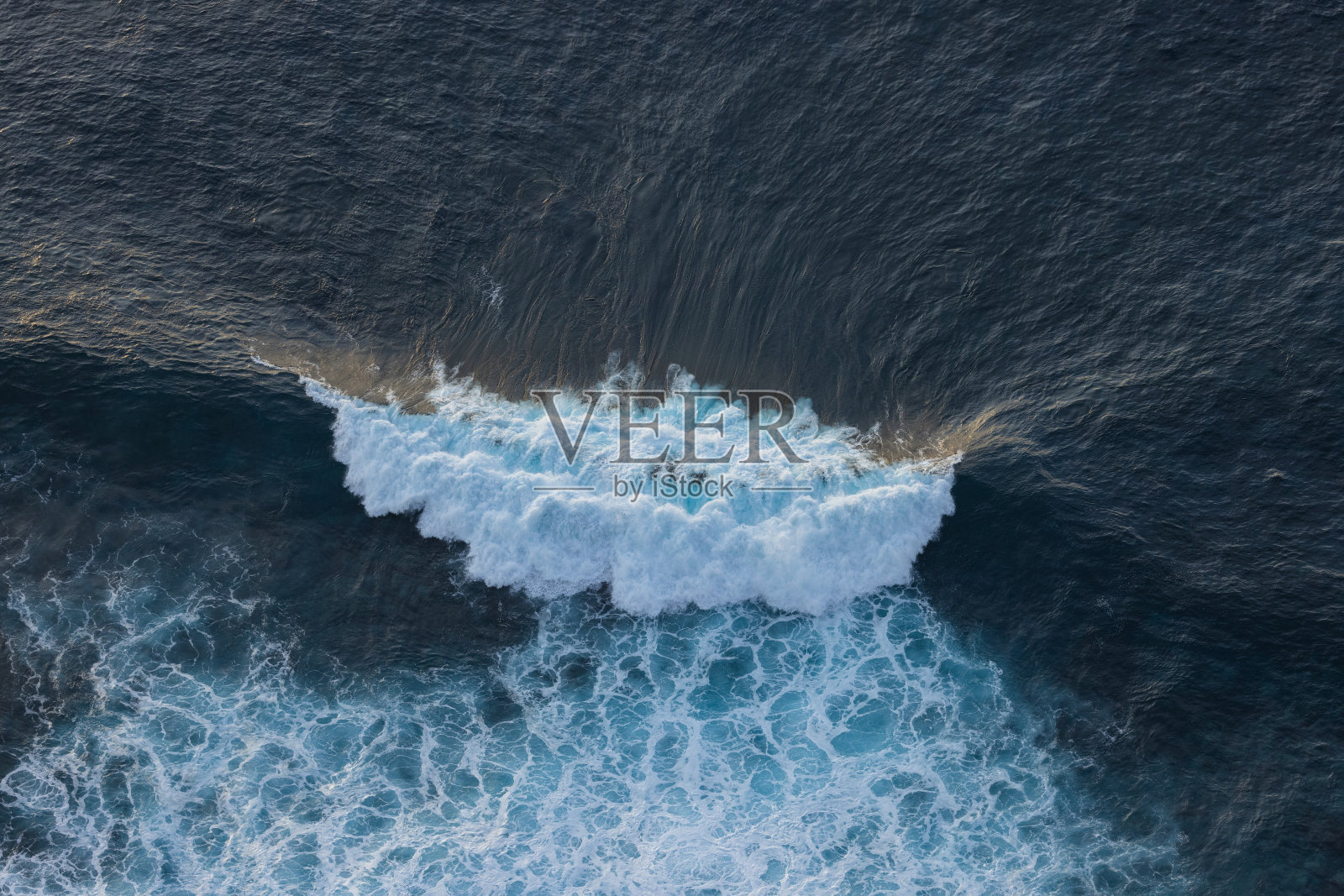 日落时被太阳照亮的巨浪。海浪非常适合冲浪。照片摄影图片