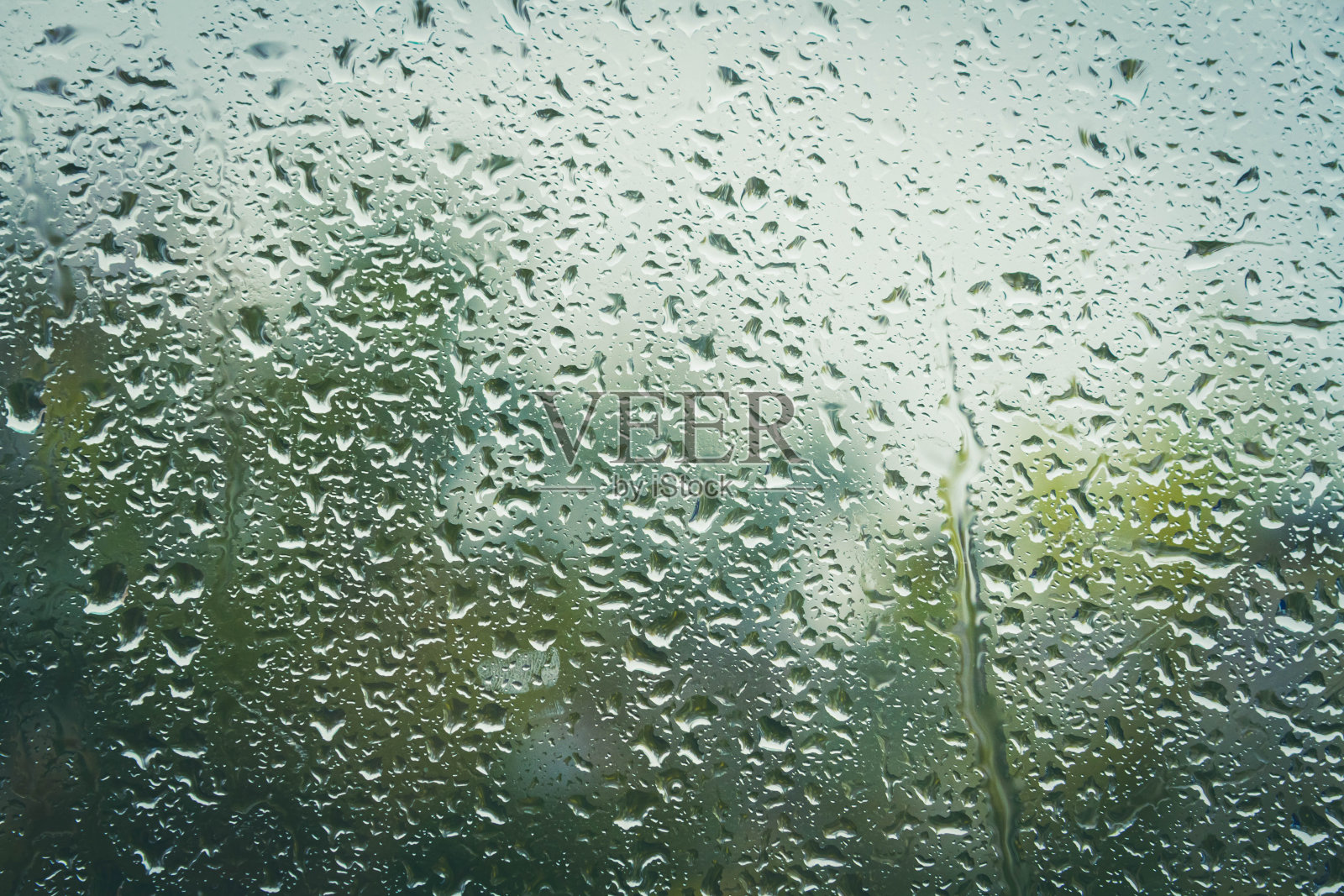 雨后雨滴落在玻璃上。窗外秋高气爽。窗外下雨了。照片摄影图片