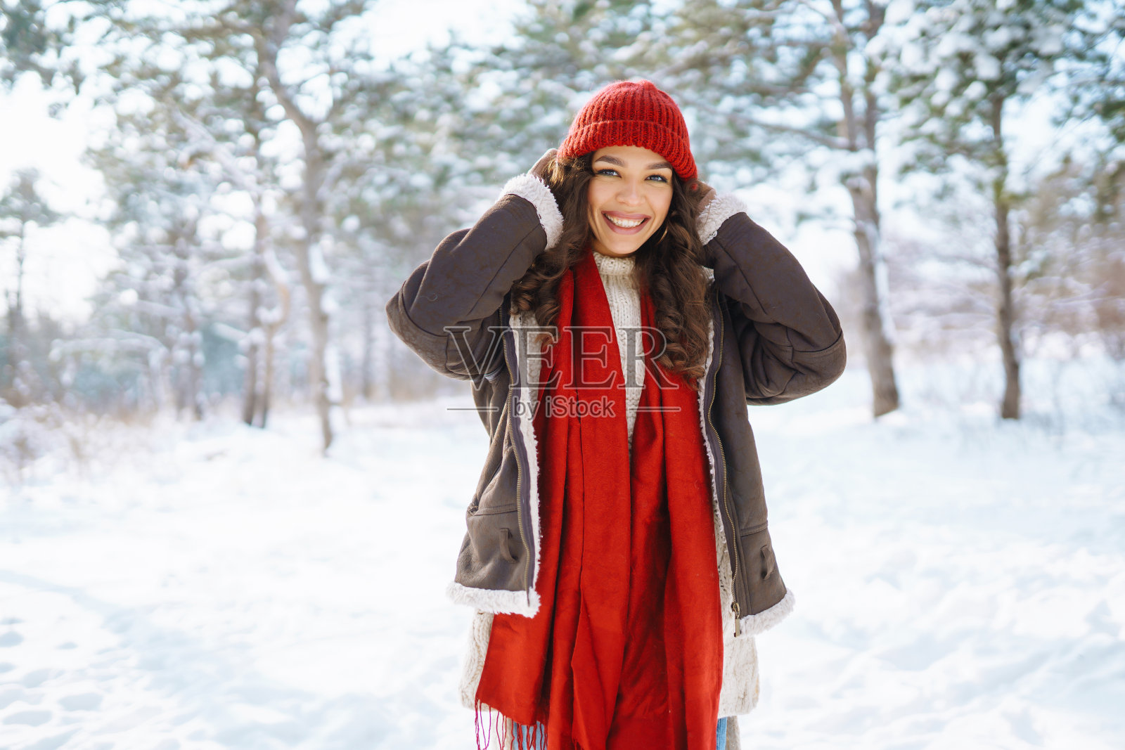 快乐的女人站在雪树间，享受初雪。假期、休息、旅行概念照片摄影图片