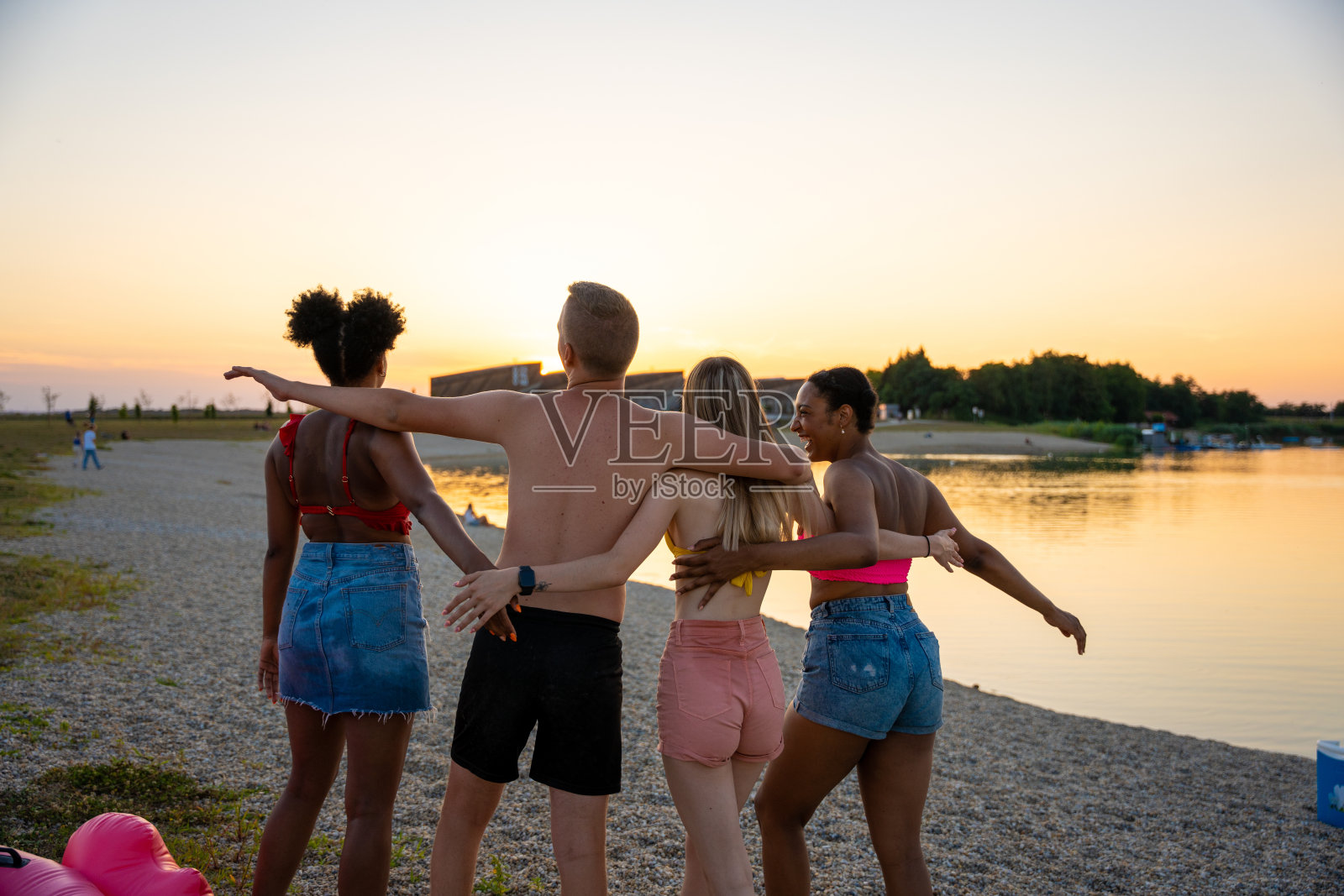 后视图的朋友与臂弯享受在湖岸照片摄影图片