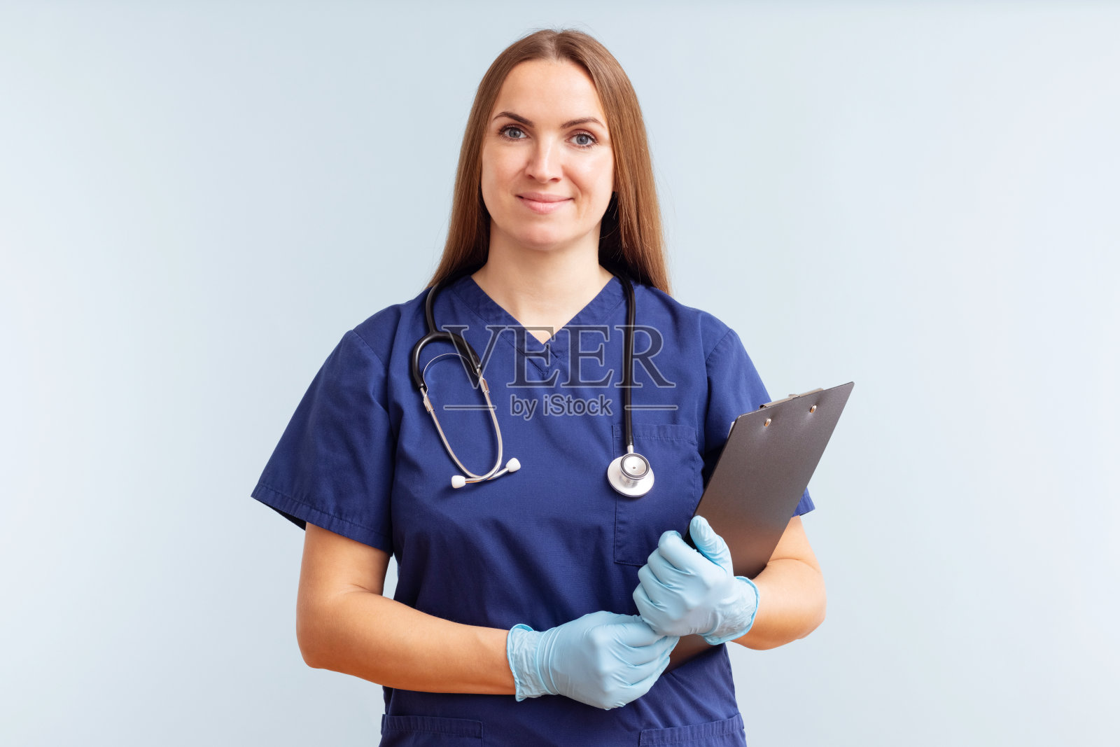 女护士或医生，蓝色背景的写字板照片摄影图片