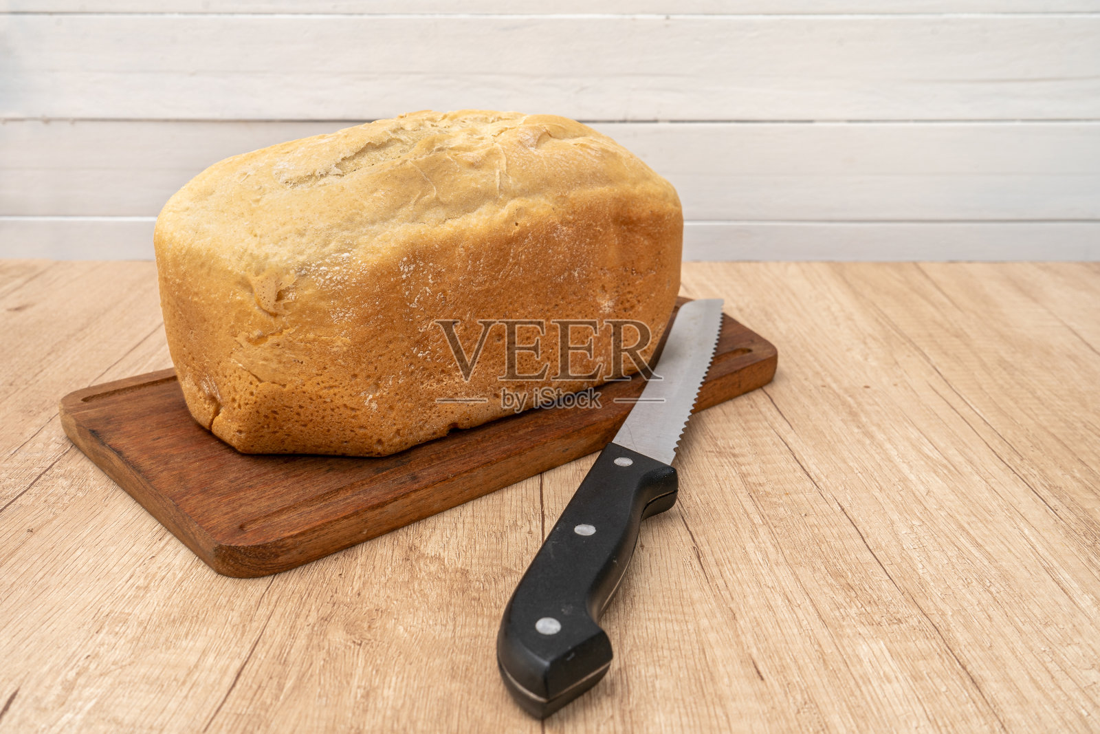 用面包刀把面包放在木板上。文本空格。照片摄影图片