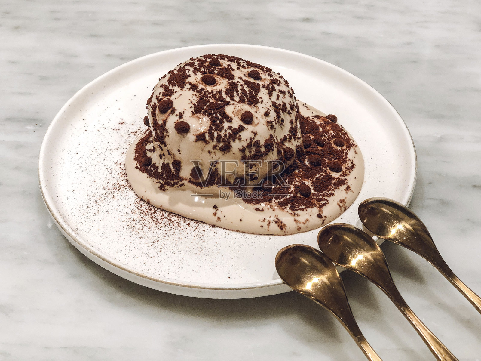 特写的一部分美味，甜提拉米苏蛋糕与三个勺子在白色的盘子照片摄影图片