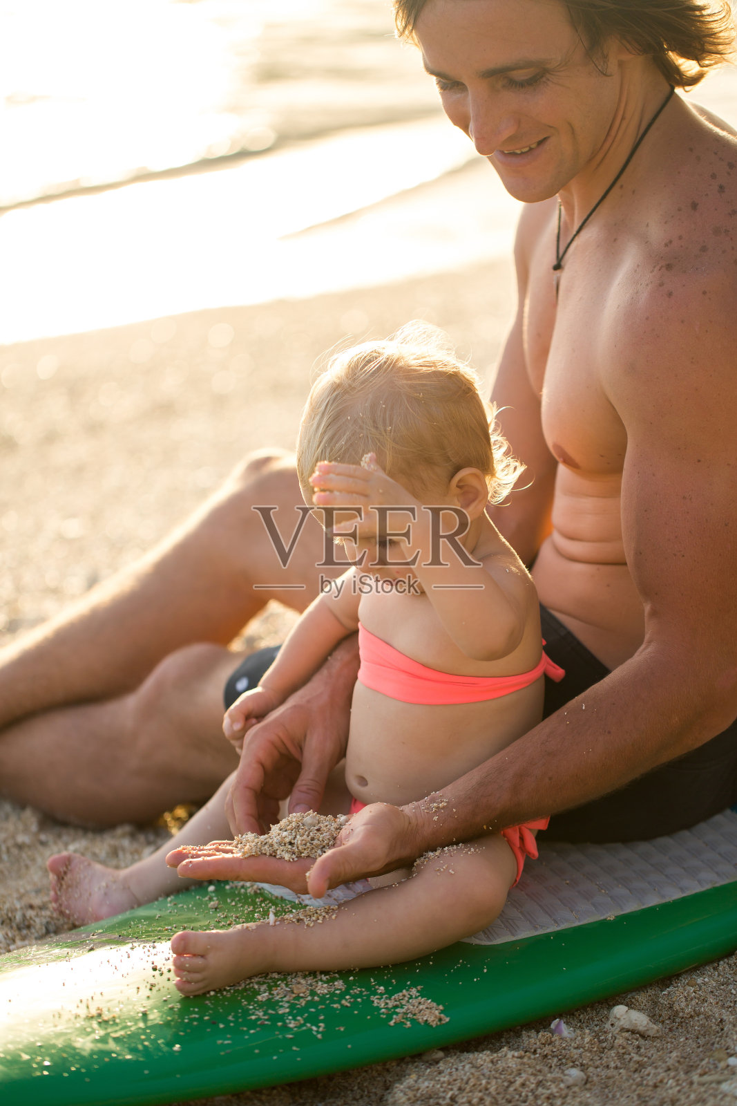 快乐的父亲和他的女儿在海滩上玩耍照片摄影图片