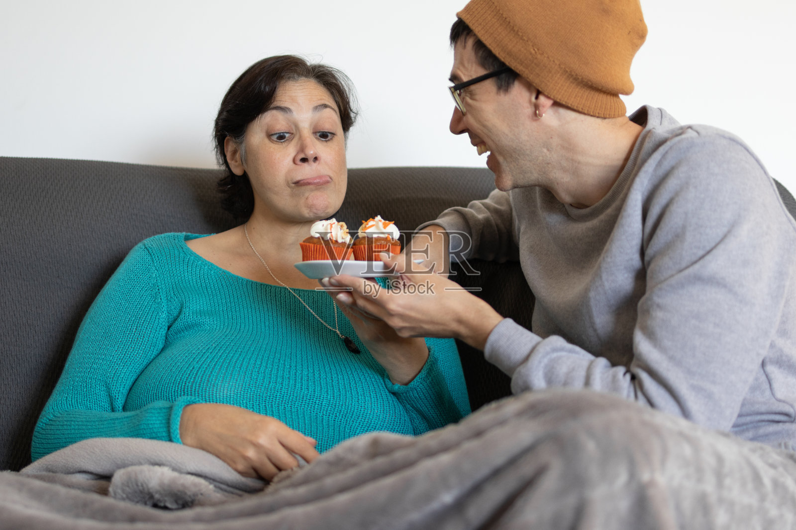 中东中年妇女和年轻白人男子情侣在情人节分享纯素胡萝卜松饼和纸杯蛋糕照片摄影图片