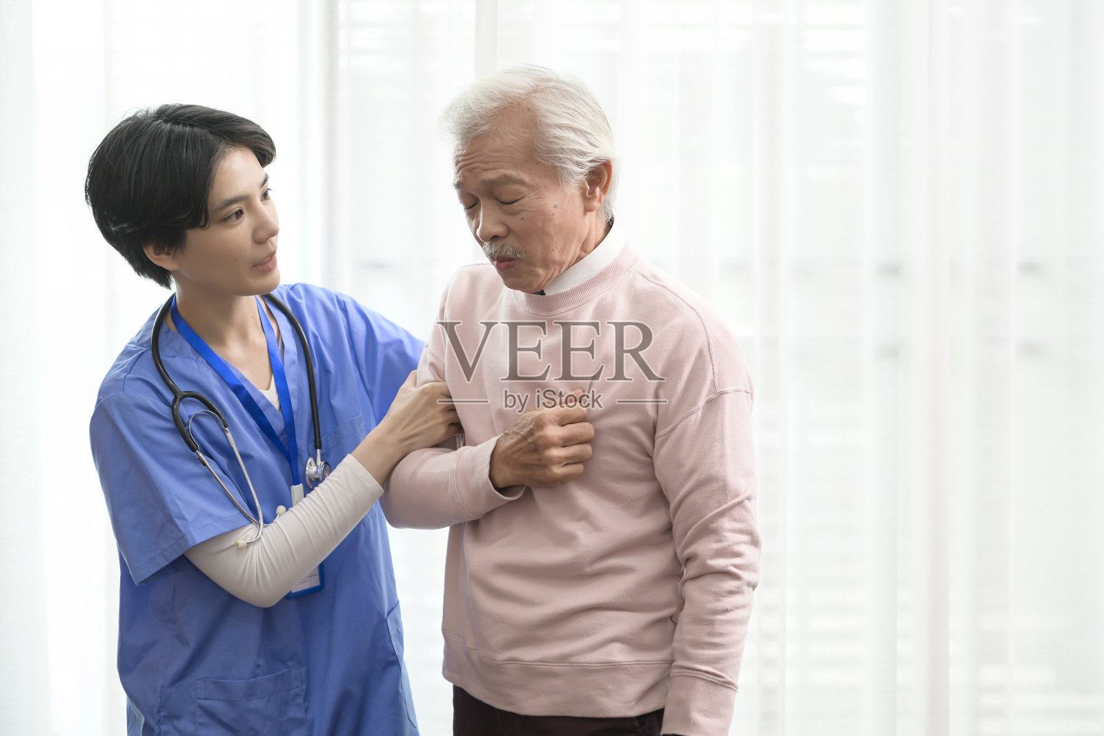 亚洲护士在老年保健中心帮助患有心脏病和胸痛的老人。照片摄影图片