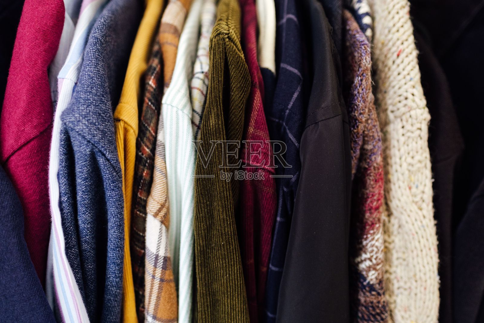 奶油色衣橱的衣架上挂着一组衣服照片摄影图片