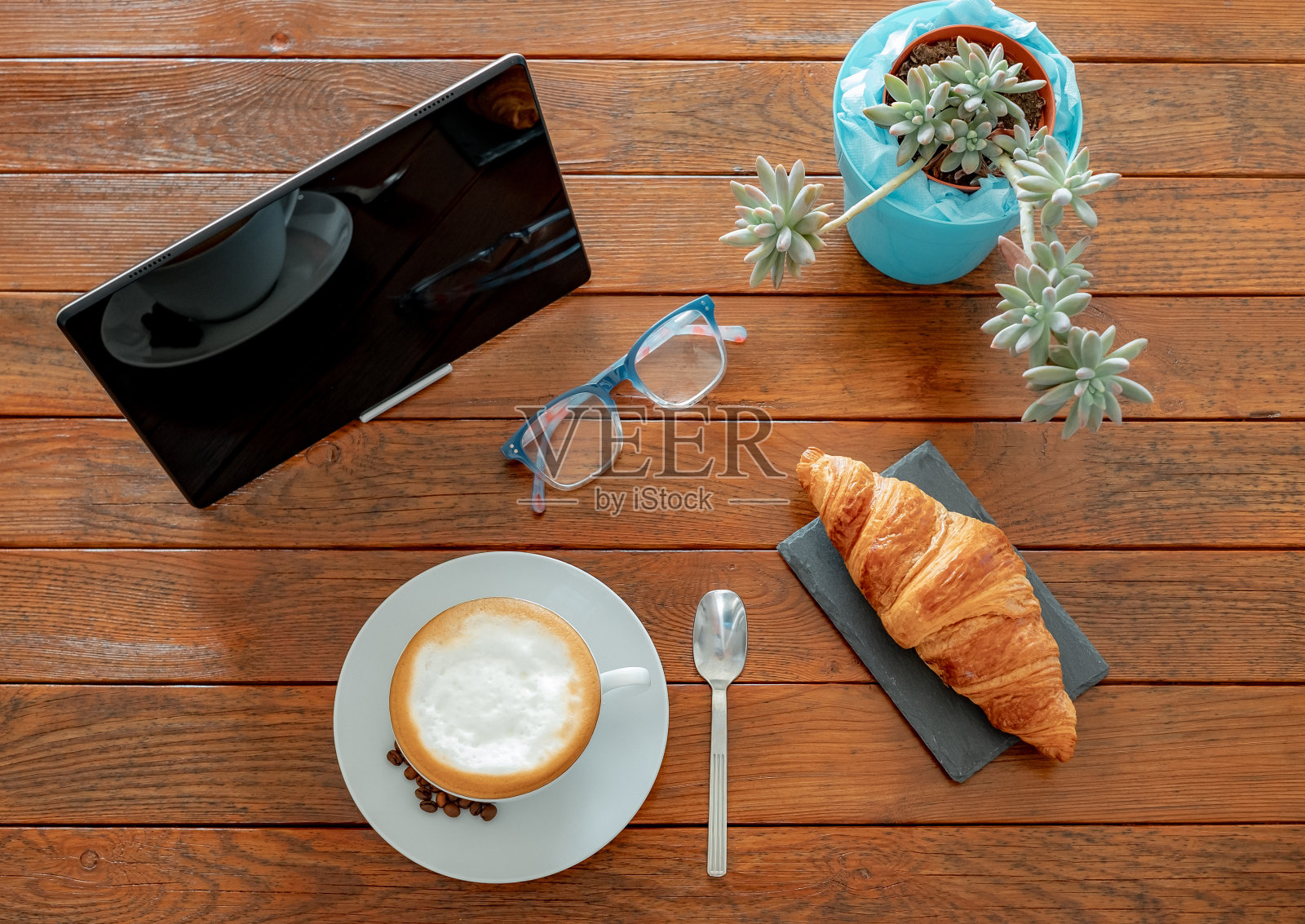 早餐时间的俯视图热卡布奇诺和法国羊角包。突发新闻的数字平板，早上好，在质朴的木桌上照片摄影图片