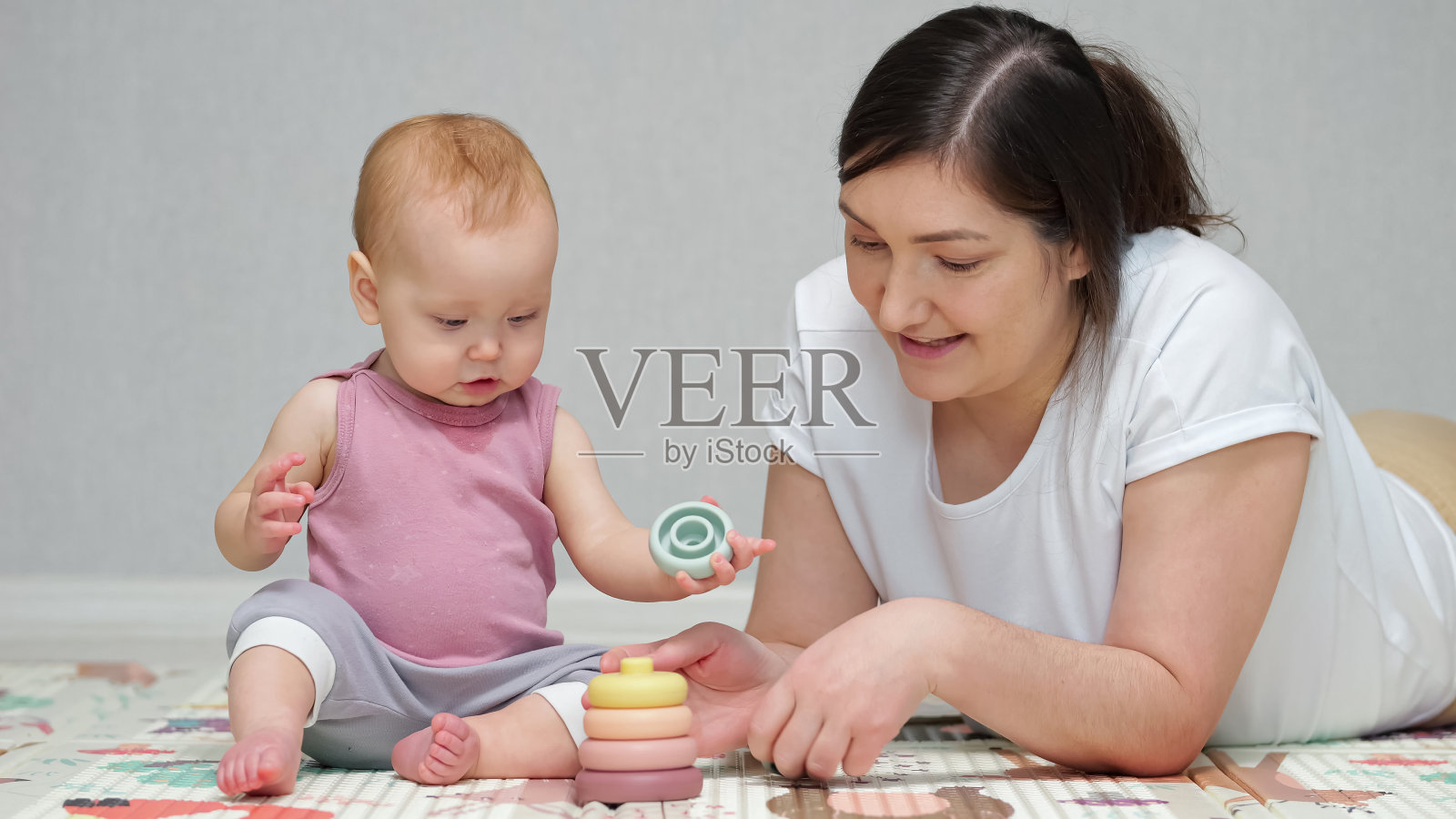 女婴喜欢和妈妈在地上玩金字塔玩具照片摄影图片