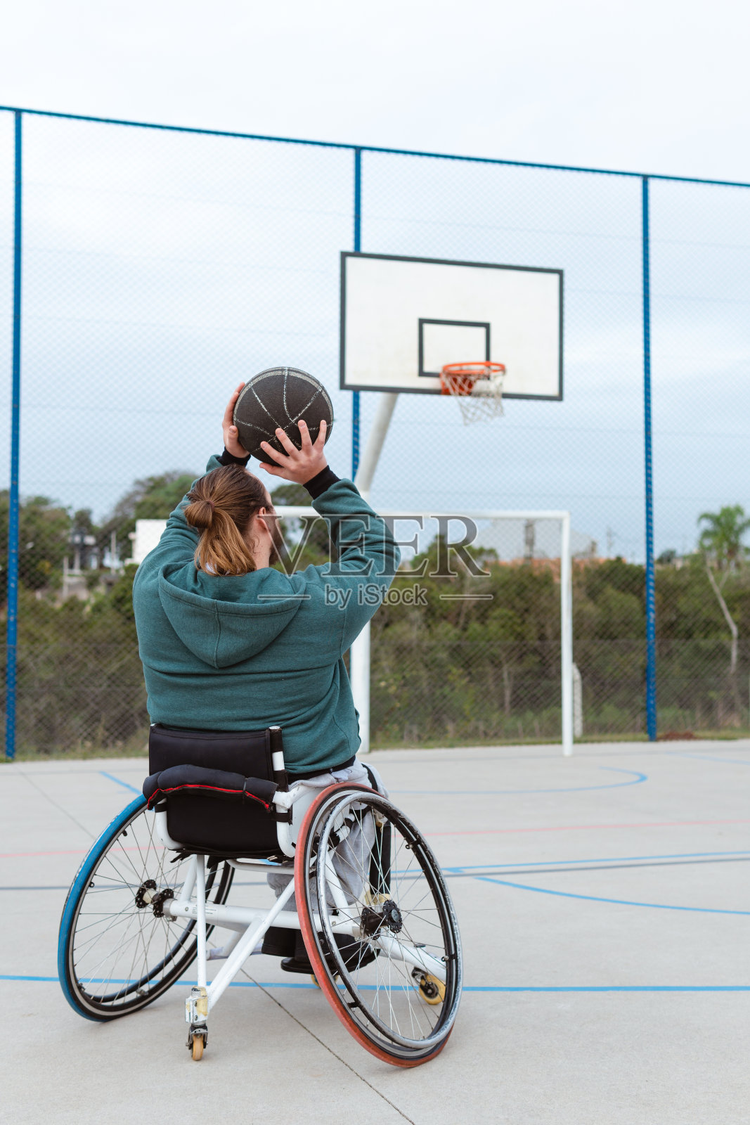 残疾人坐在轮椅上扔球照片摄影图片