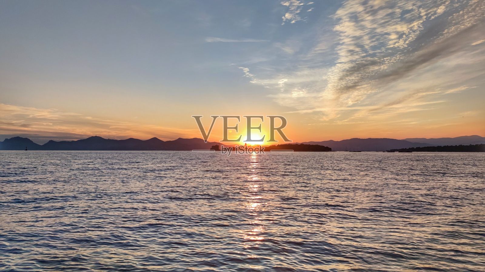 风景如画的日落和山脉轮廓横跨海岸照片摄影图片