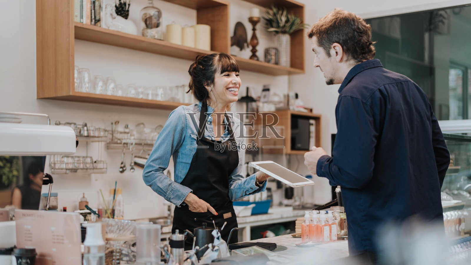 白人女咖啡师在咖啡店为顾客点单。女咖啡师用平板电脑点菜。咖啡老板的概念。照片摄影图片