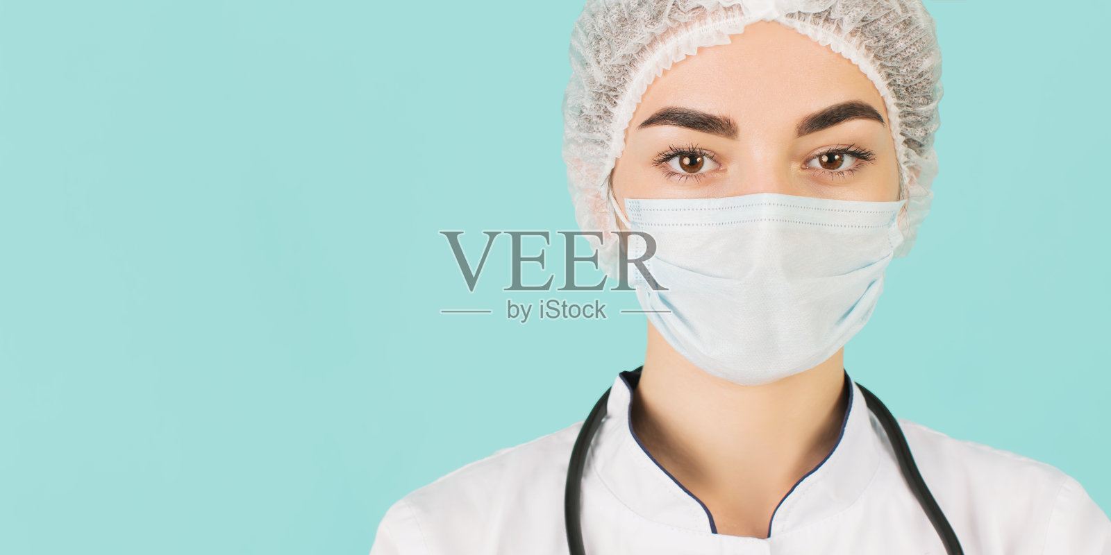 护士戴着面具，蓝色背景。医生照片摄影图片