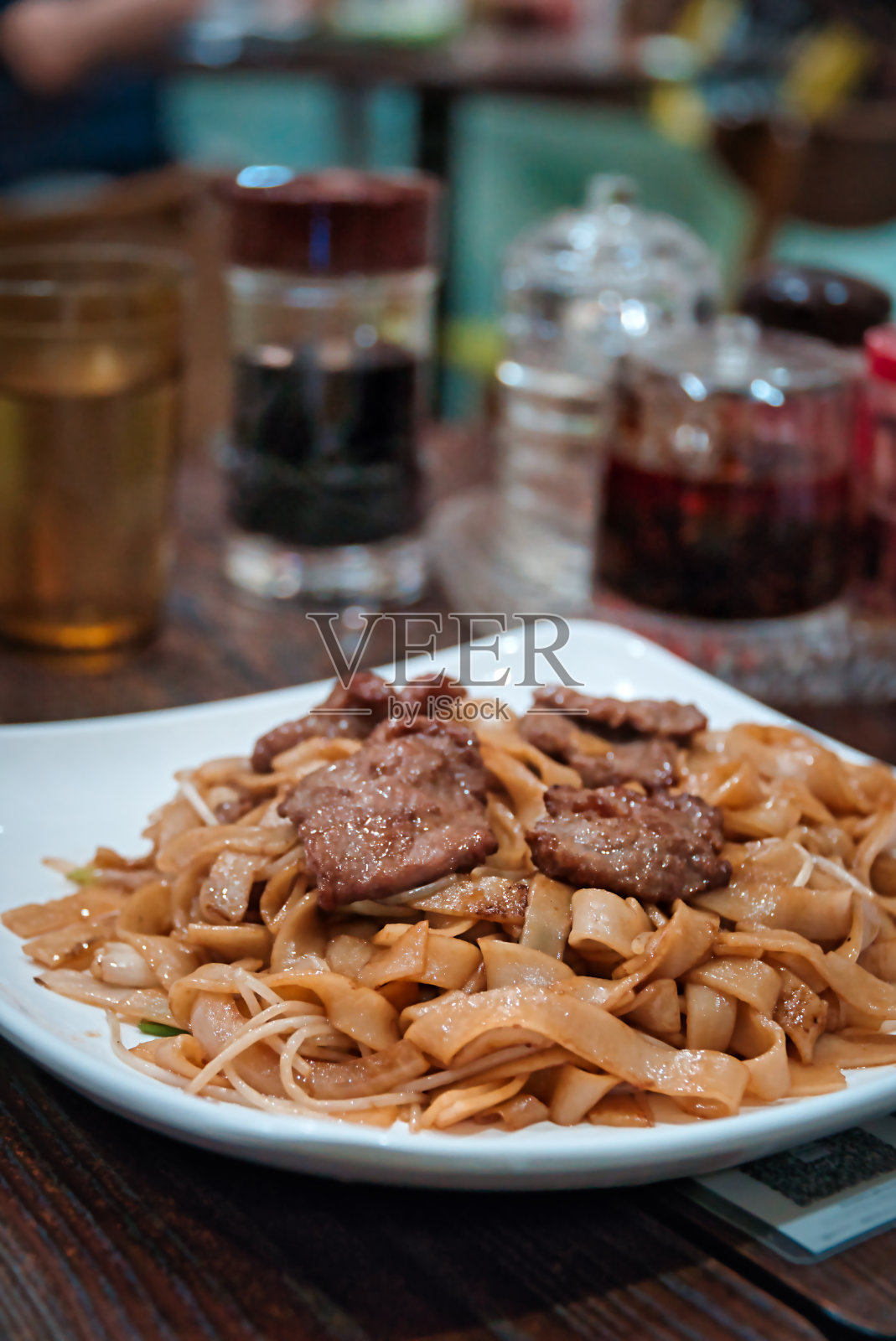 在一家中餐馆里的牛肉面条。照片摄影图片