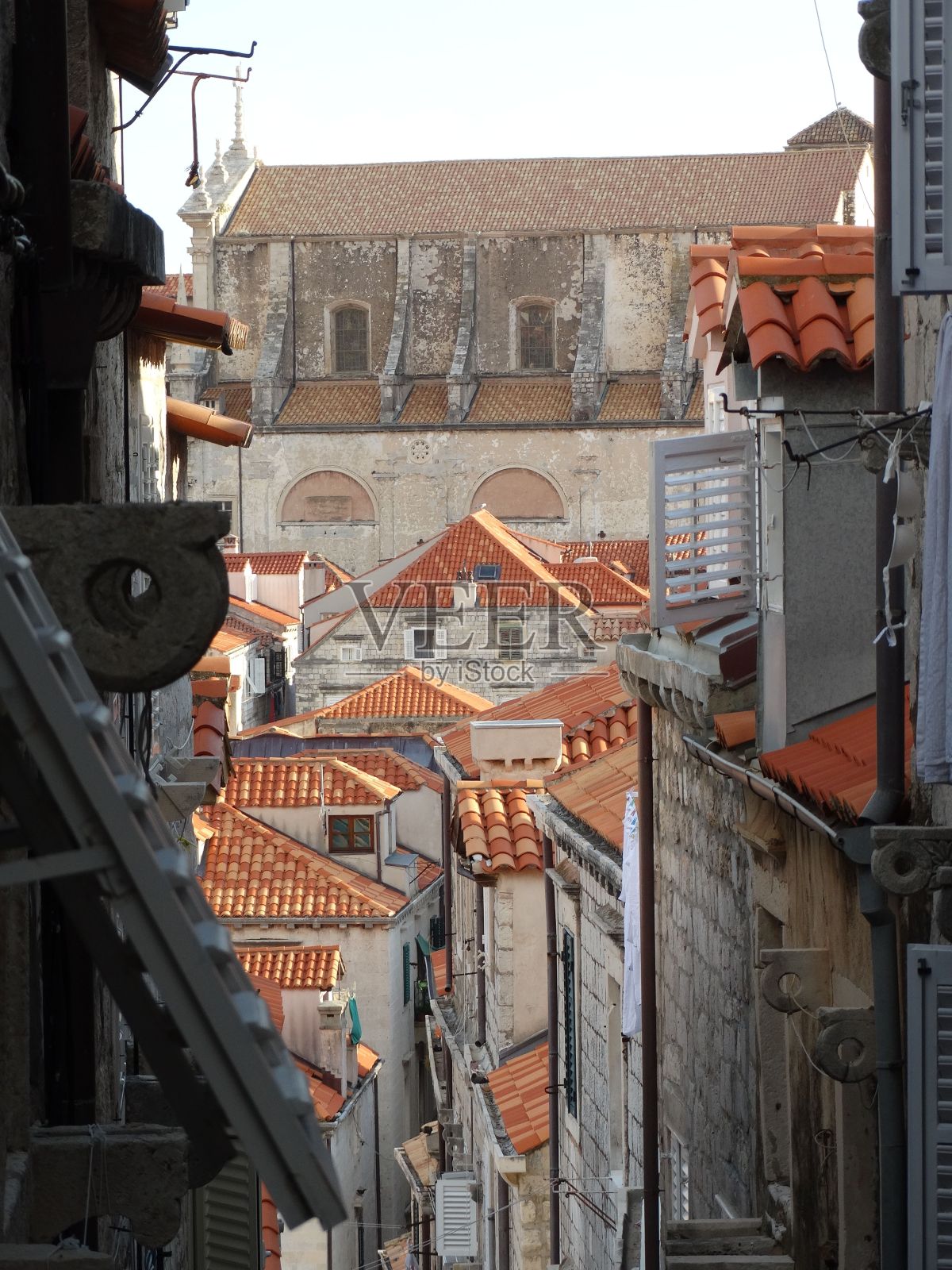 狭窄的街道，白天有红屋顶的房子照片摄影图片