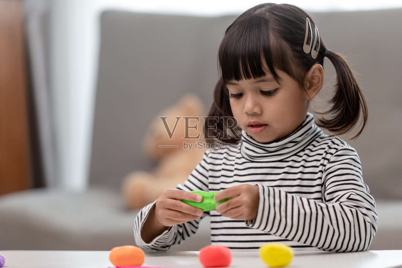 亚洲孩子玩陶土塑造的形状，在玩中学习照片摄影图片