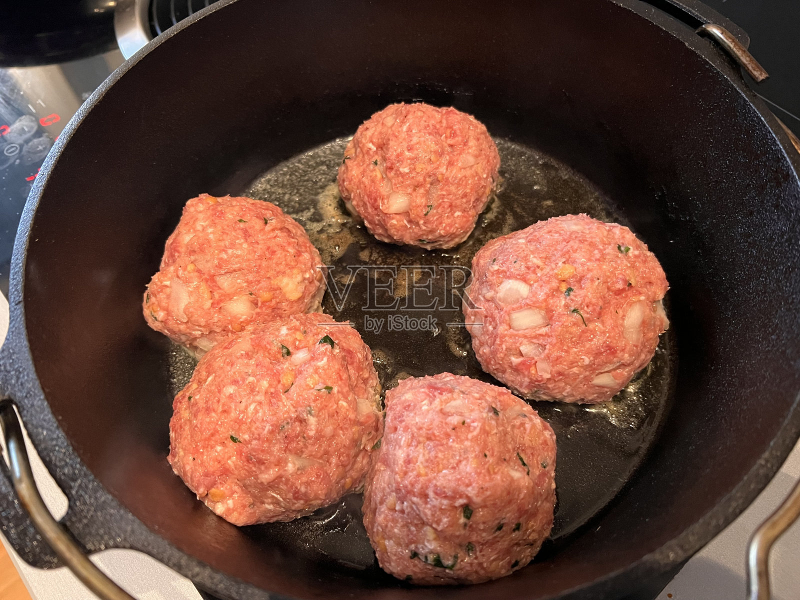 荷兰烤炉，用于烹饪肉丸，酸豆，白葡萄酒酱，玉米粥照片摄影图片