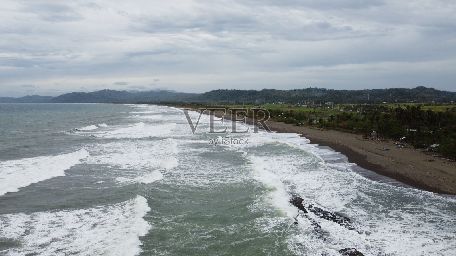在阴沉的天气里，波浪形海岸的风景照片摄影图片