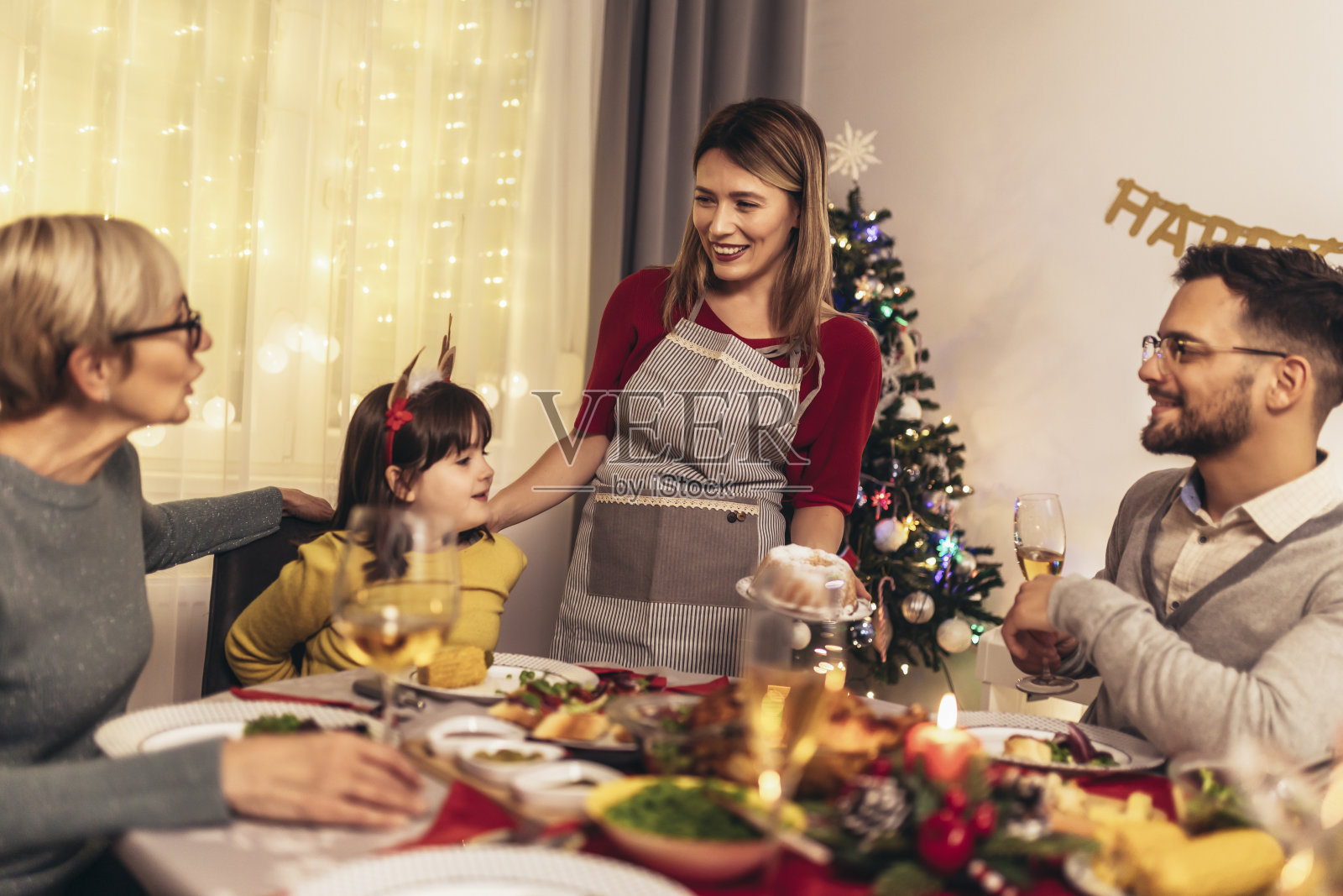 快乐的几代人在一起享受午餐在家里。家人在家里吃圣诞晚餐照片摄影图片