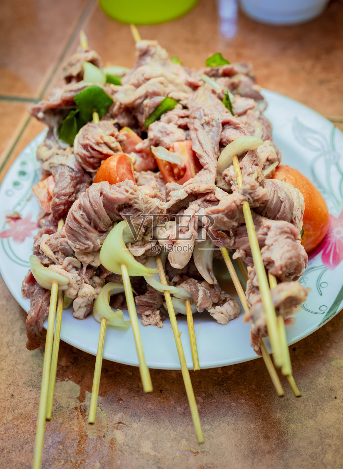 生牛肉串放在盘子里。近距离的生牛肉串与配料。新鲜的生牛肉串放在盘子里。准备生牛肉串。照片摄影图片