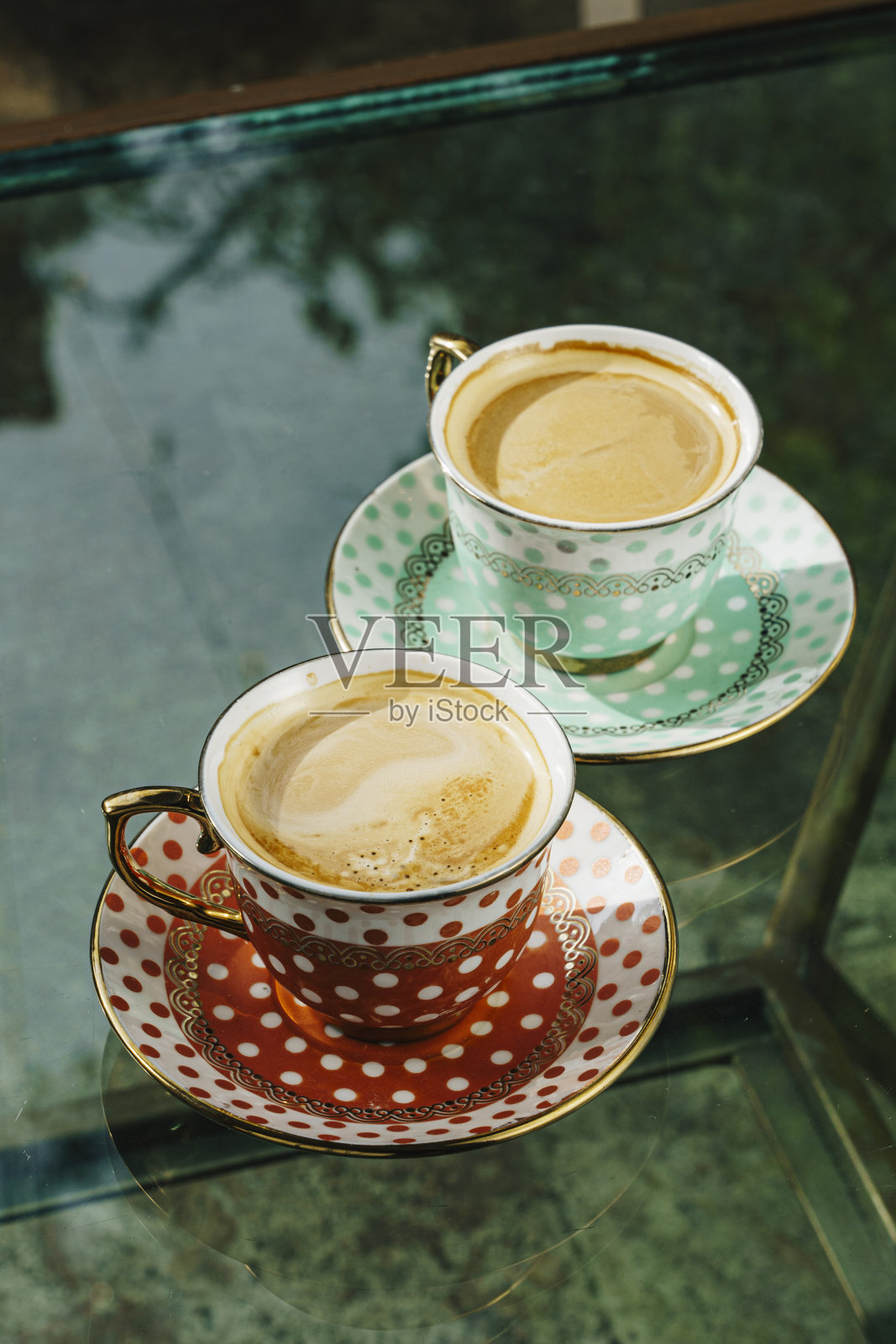 垂直特写的咖啡在红色和蓝色的古董杯在玻璃桌上照片摄影图片