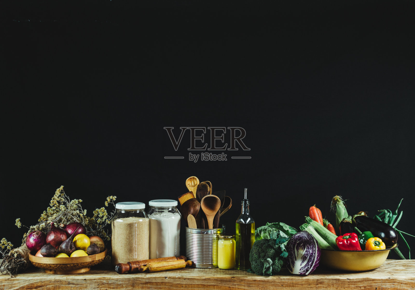 厨房用具、谷物、油和新鲜蔬菜放在黑色背景的木桌上照片摄影图片