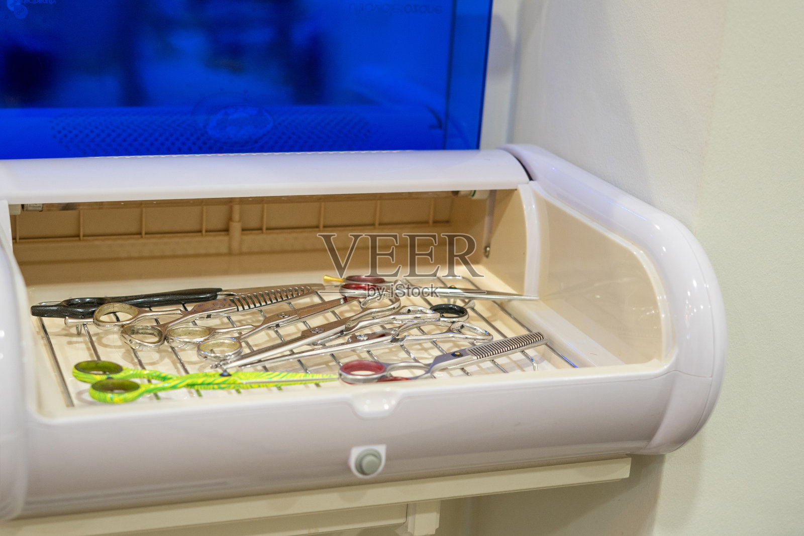 消毒器里有一组美容院的剪刀。卫生的概念。照片摄影图片