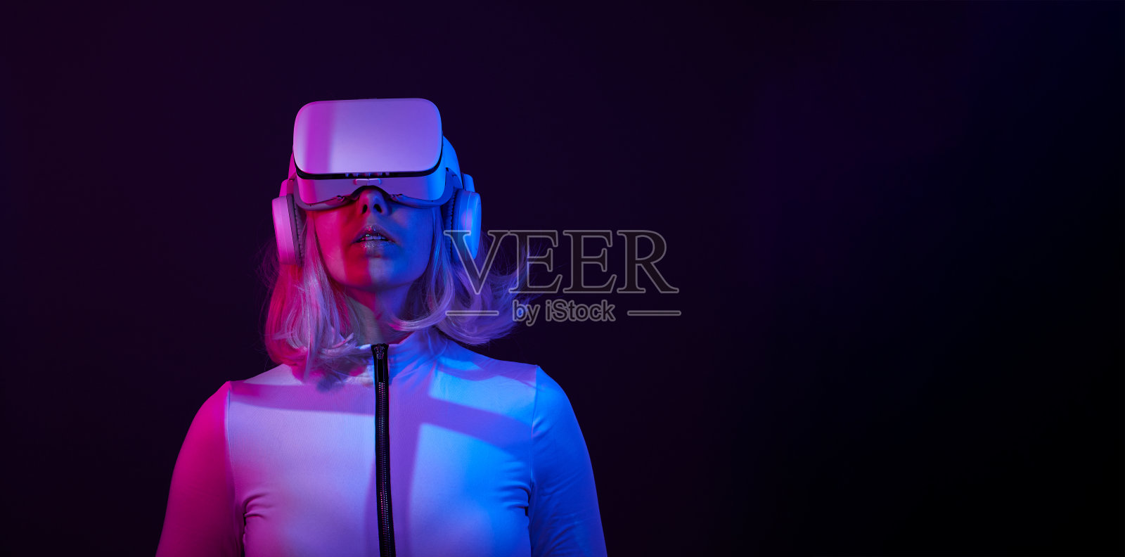 女人在虚拟现实的霓虹灯颜色的护目镜。照片摄影图片