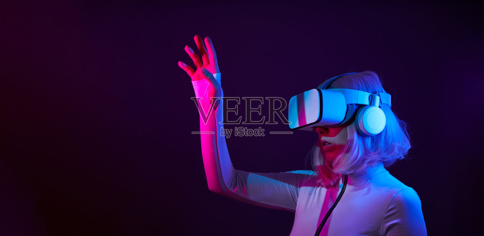 女人在虚拟现实的霓虹灯颜色的护目镜。照片摄影图片