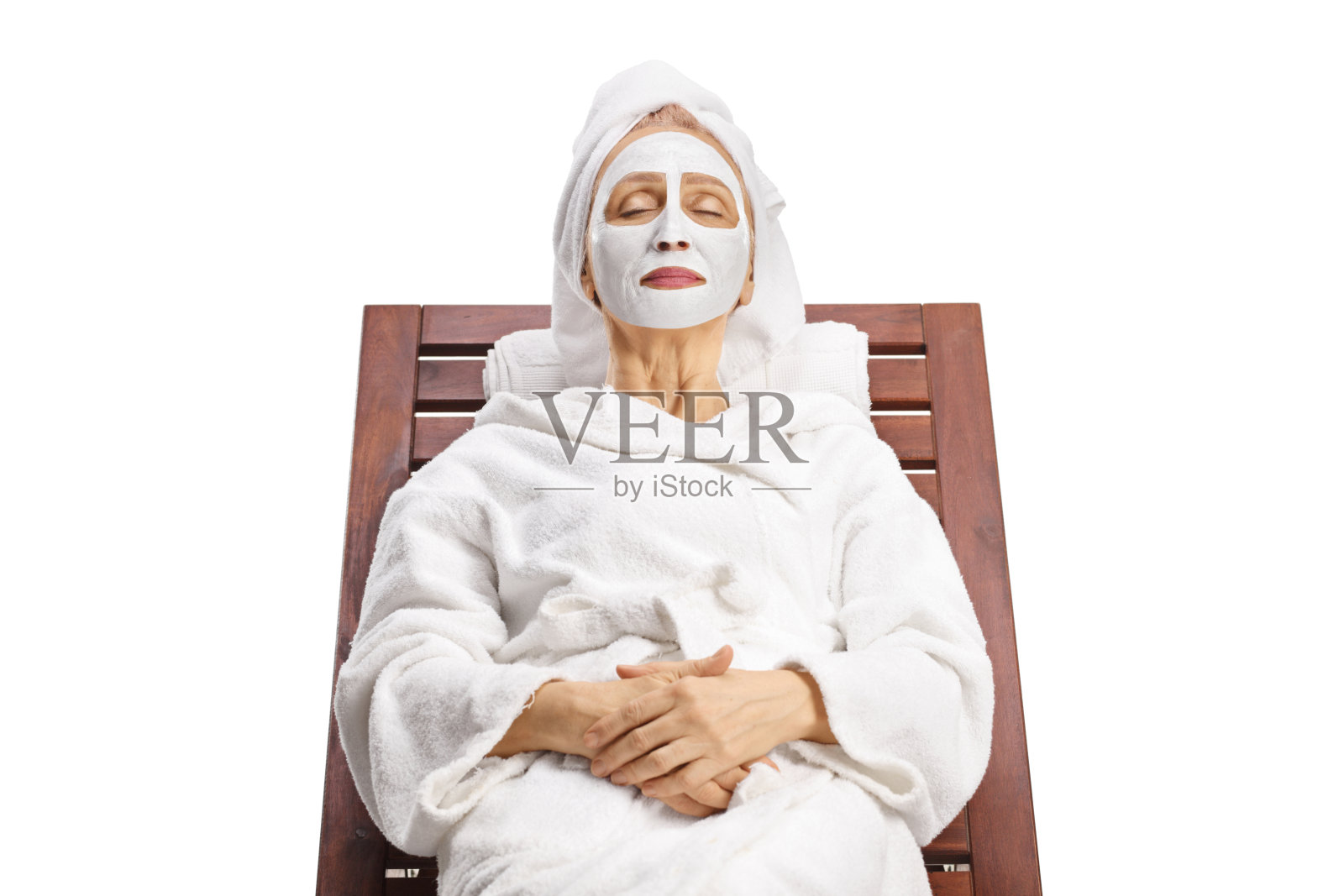 女人穿着浴袍，头发裹着毛巾，戴着白色面膜放松照片摄影图片