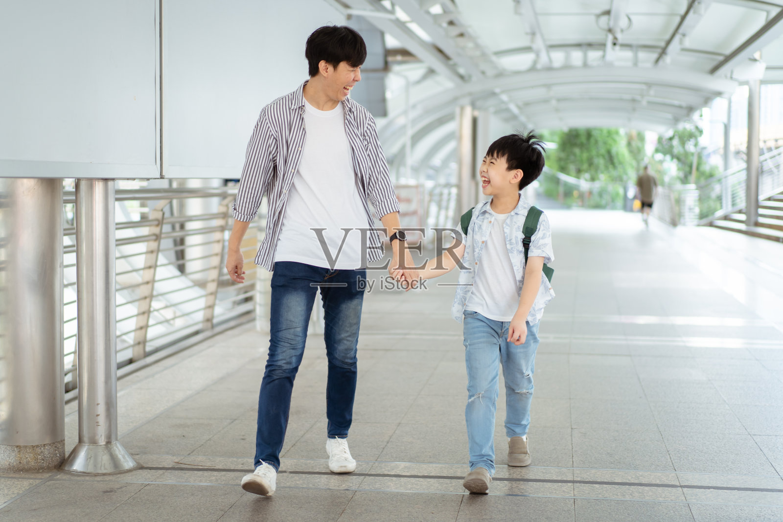 男孩和他父亲在城里。照片摄影图片