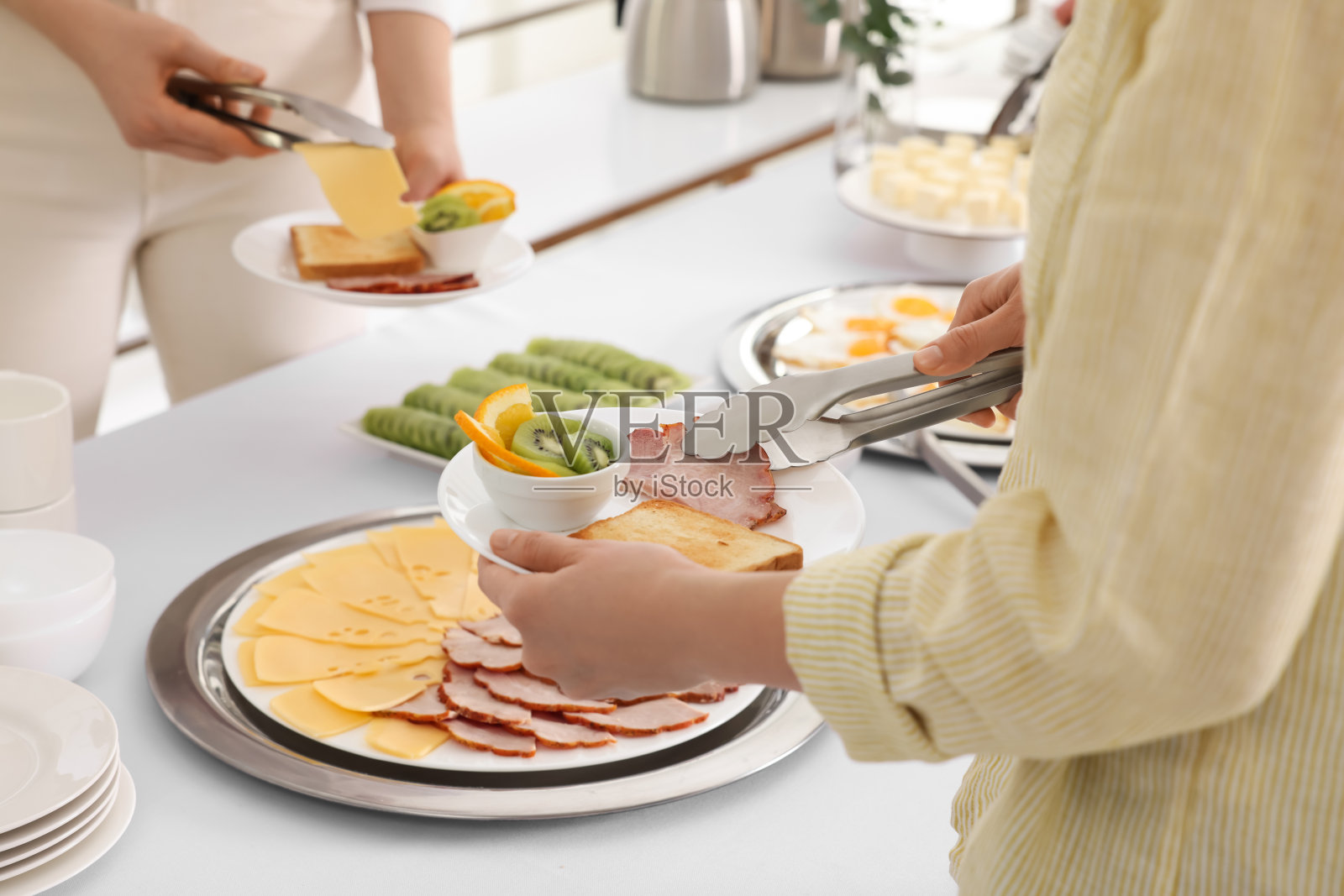 人们在早餐时吃东西，特写。自助餐服务照片摄影图片