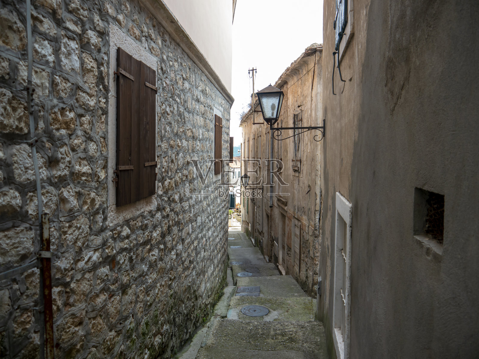 欧洲小镇狭窄的街道，石头房子的墙壁照片摄影图片