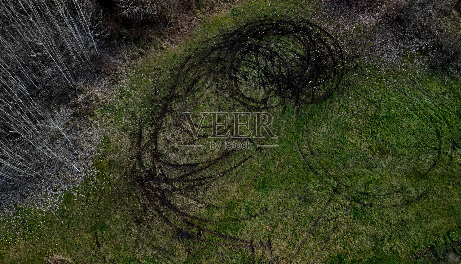汽车打滑损坏农田的证据。警方用无人机记录了年轻人在草地上驾车横冲直撞后的破坏情况。车辙变成了车轮旋转的圆圈，风景照片摄影图片