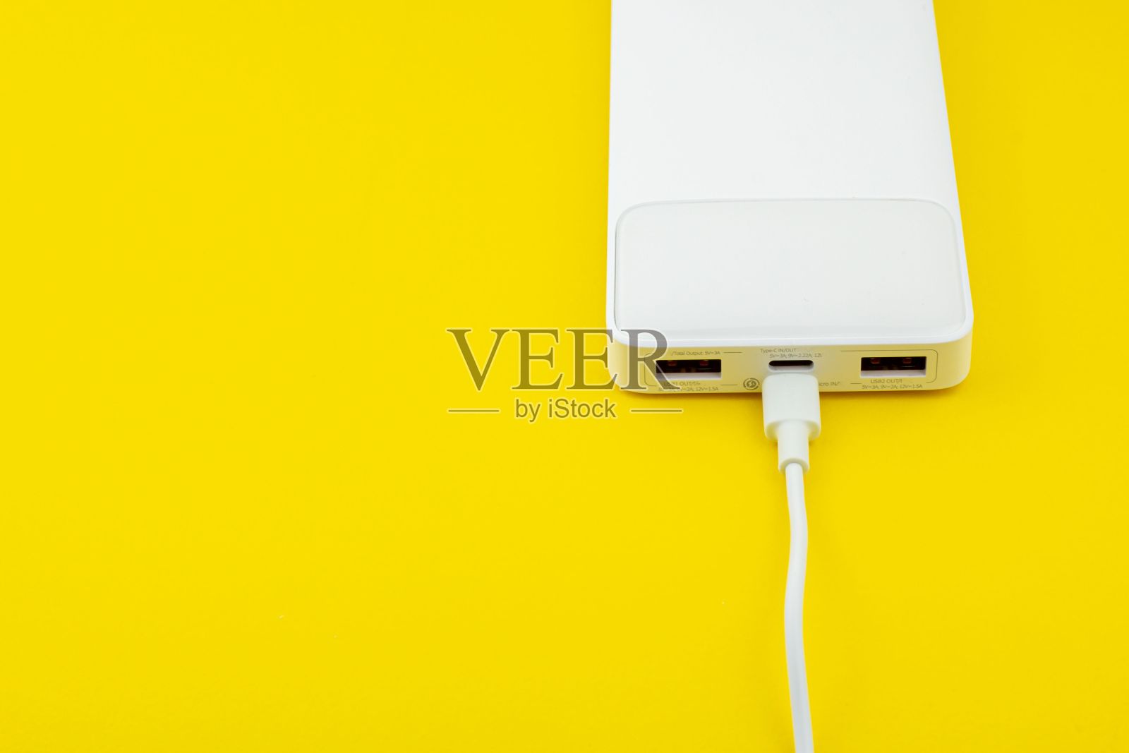 白色充电宝，黄色表面有USB线照片摄影图片