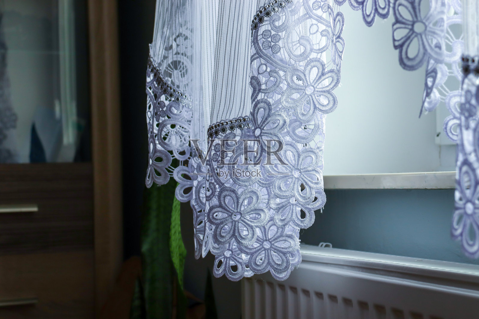 窗帘部分的特写。窗框窗帘，室内细节。公寓里漂亮的透明白色窗帘照片摄影图片