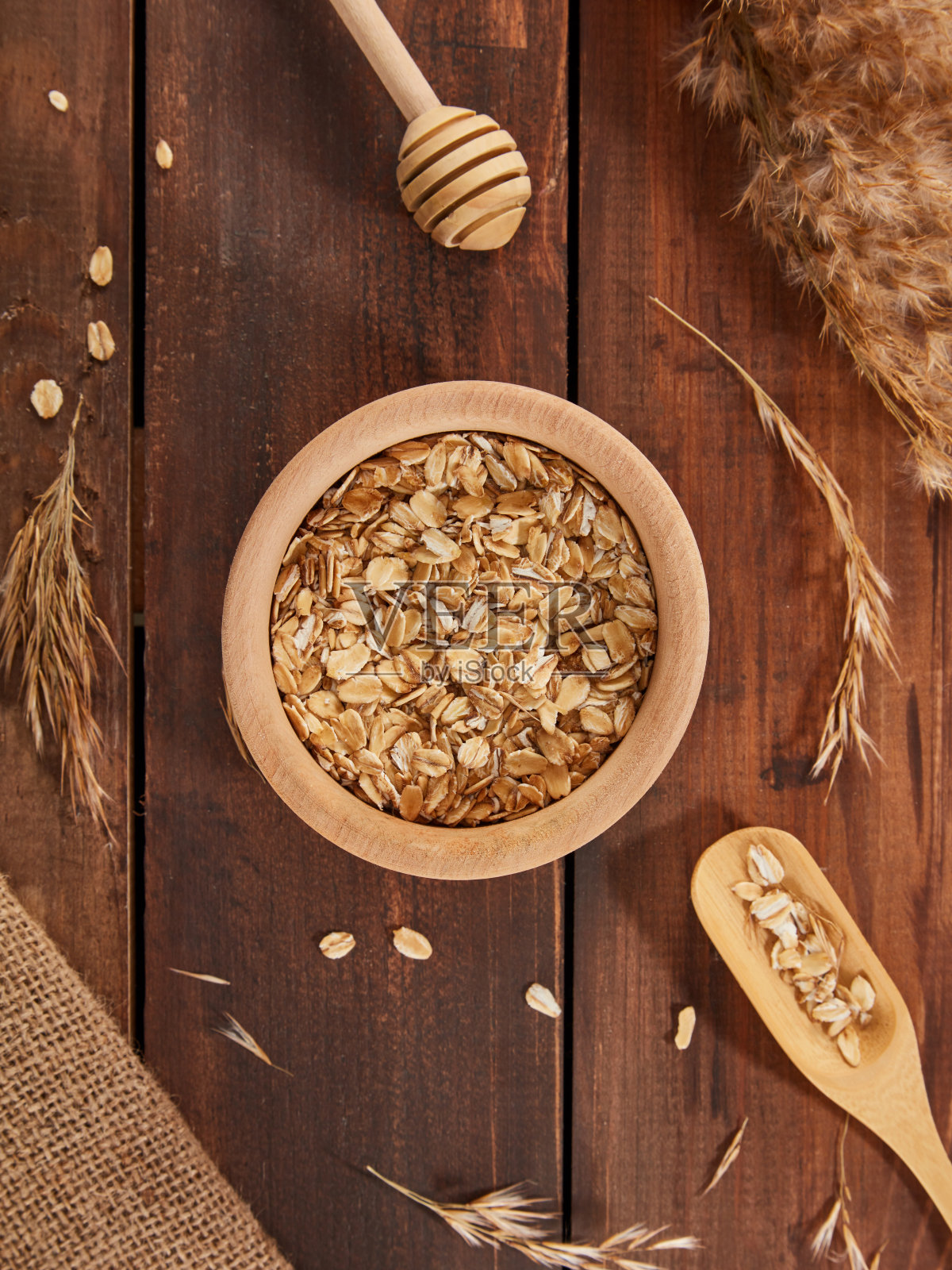 燕麦片在碗与勺子在木头背景照片摄影图片