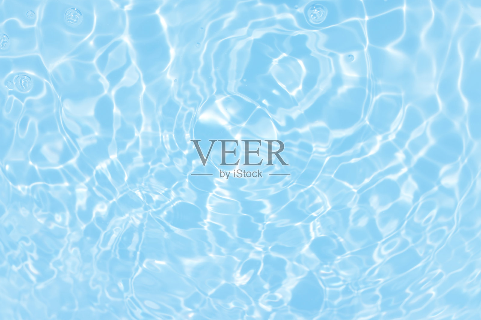 离焦模糊透明蓝色颜色清晰平静的水面纹理与飞溅和气泡。潮流抽象的自然背景。水波在阳光下带有焦散。碧水浪花闪闪发光照片摄影图片