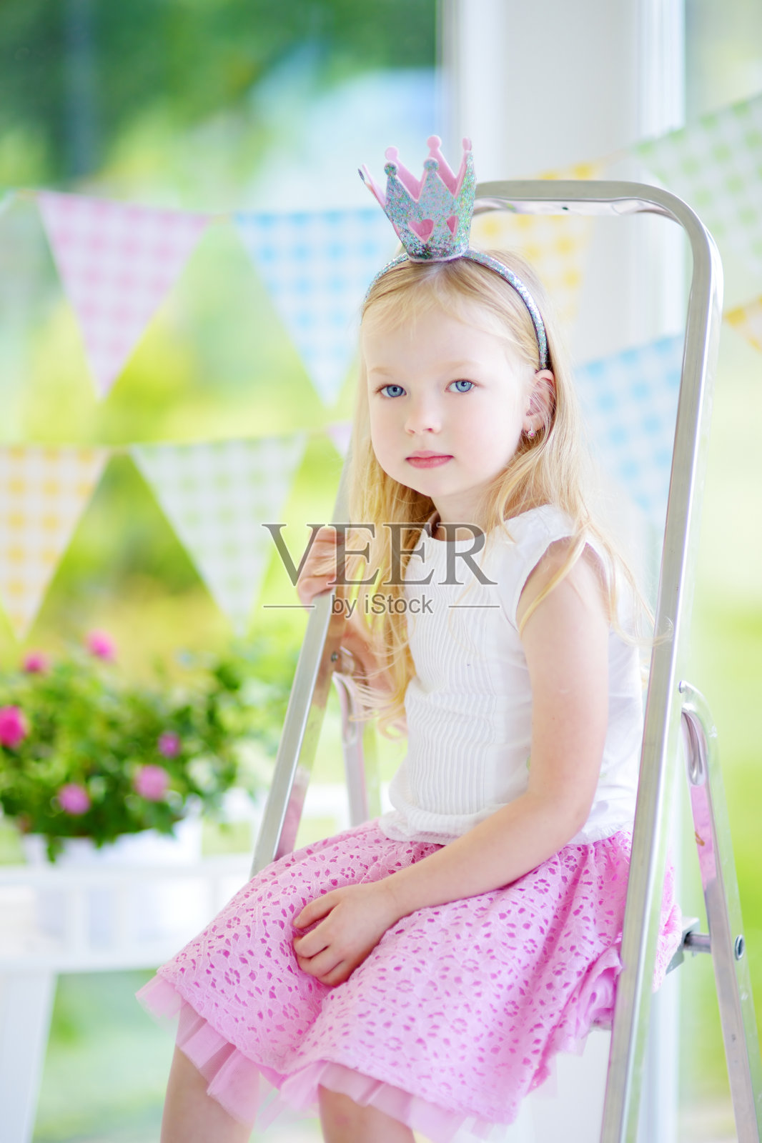 可爱的小女孩穿着漂亮的裙子和公主头饰的肖像照片摄影图片
