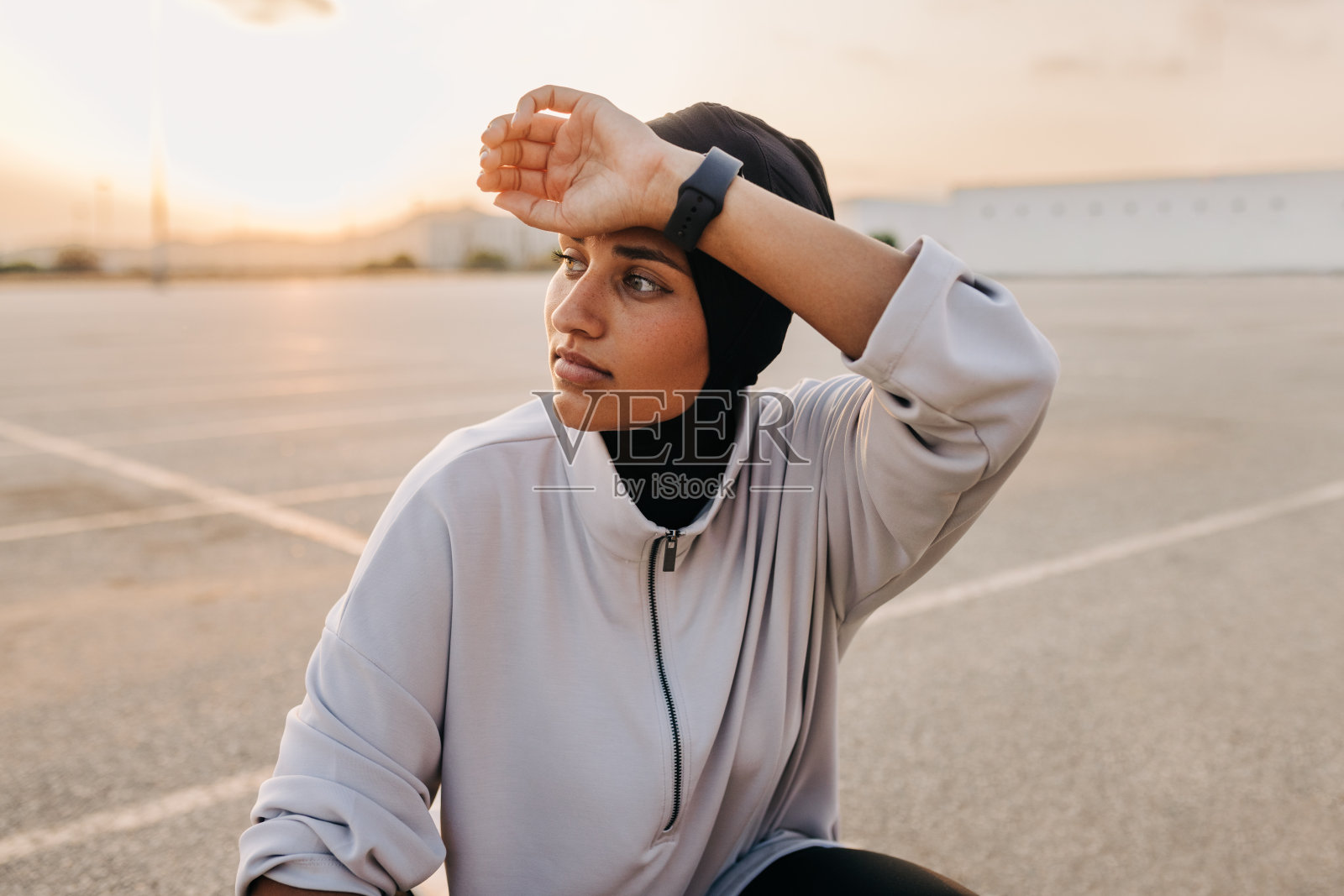 穆斯林女运动员在户外擦汗照片摄影图片