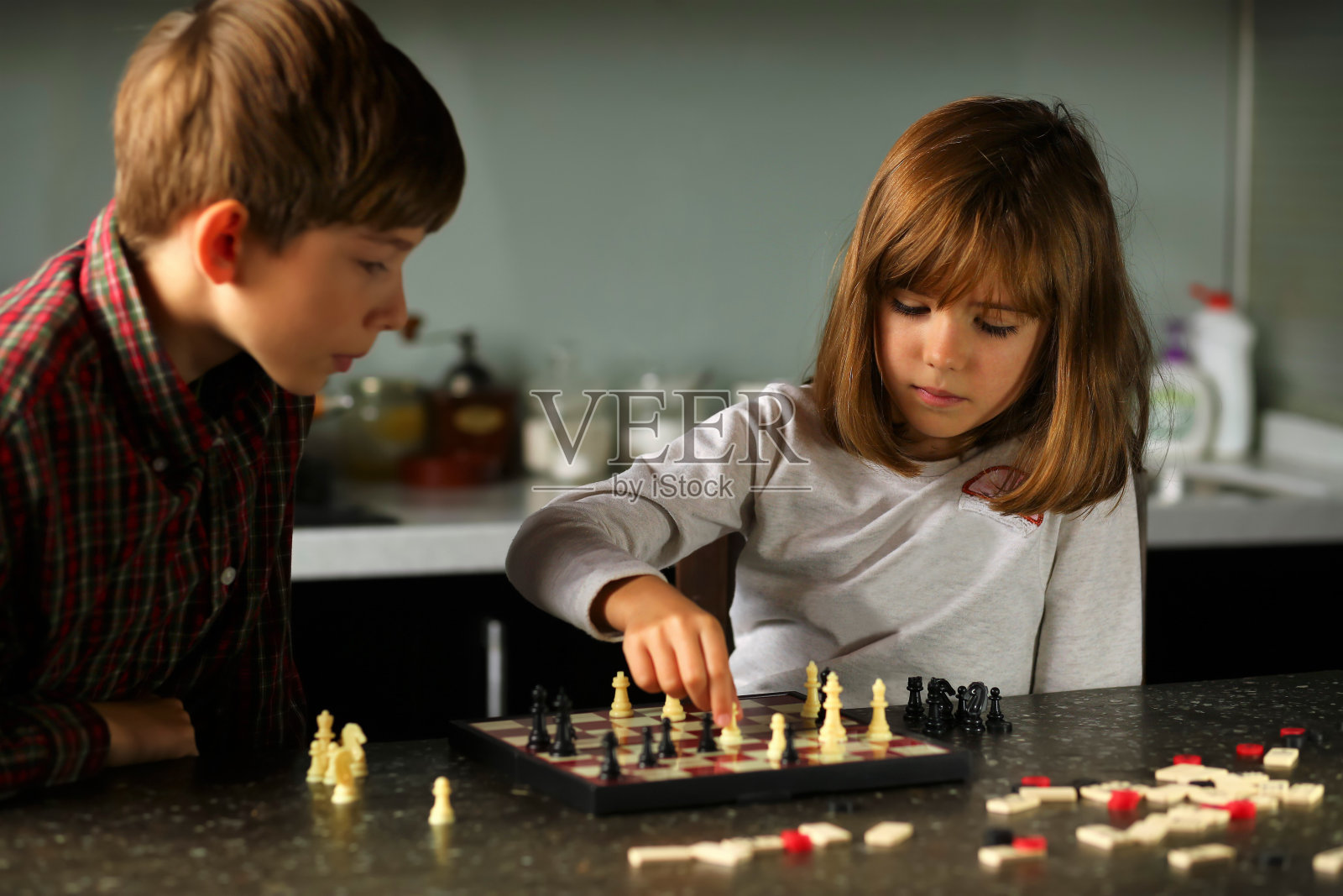 孩子们在家里的厨房里下棋照片摄影图片