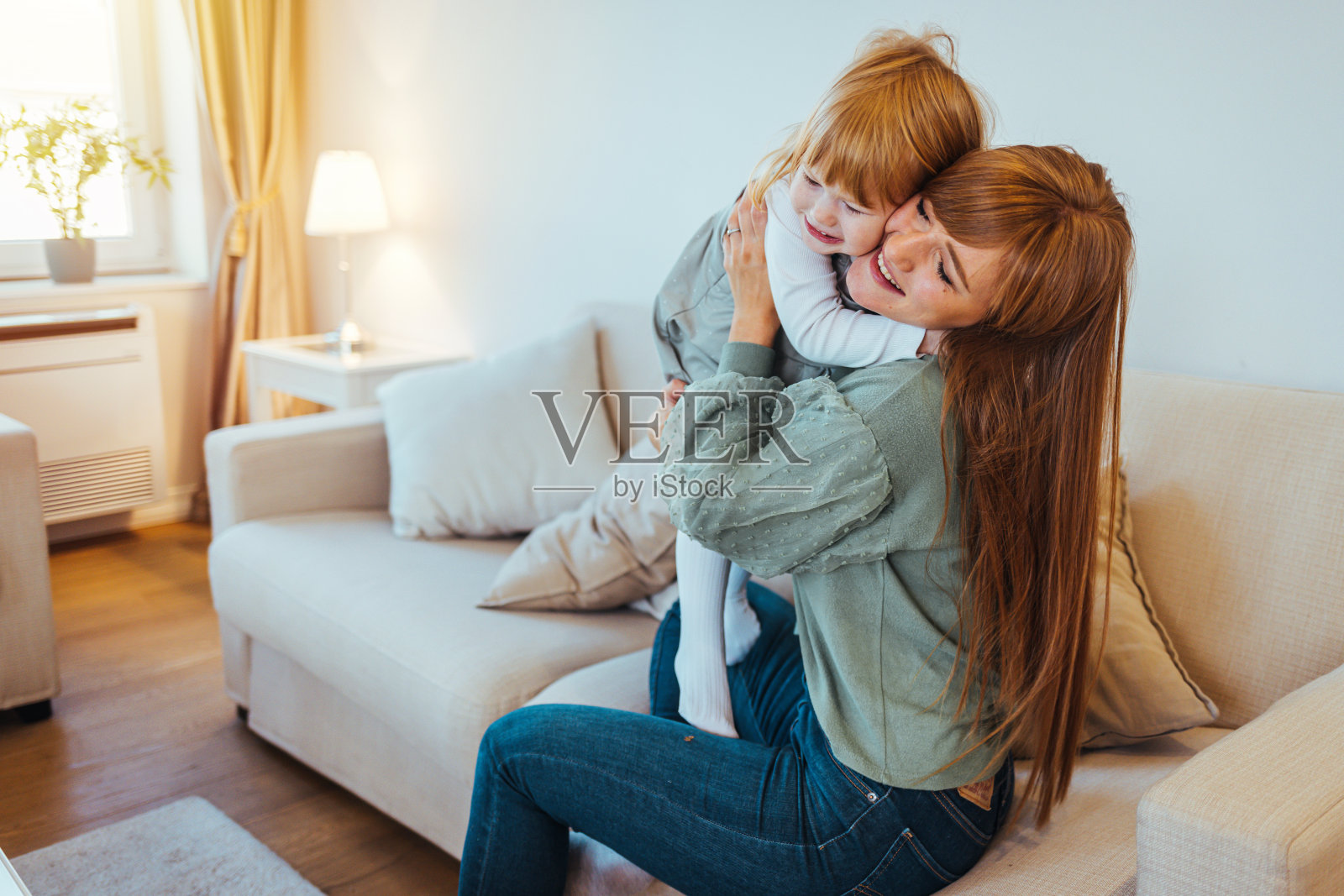 母亲在家里抱着女儿。照片摄影图片