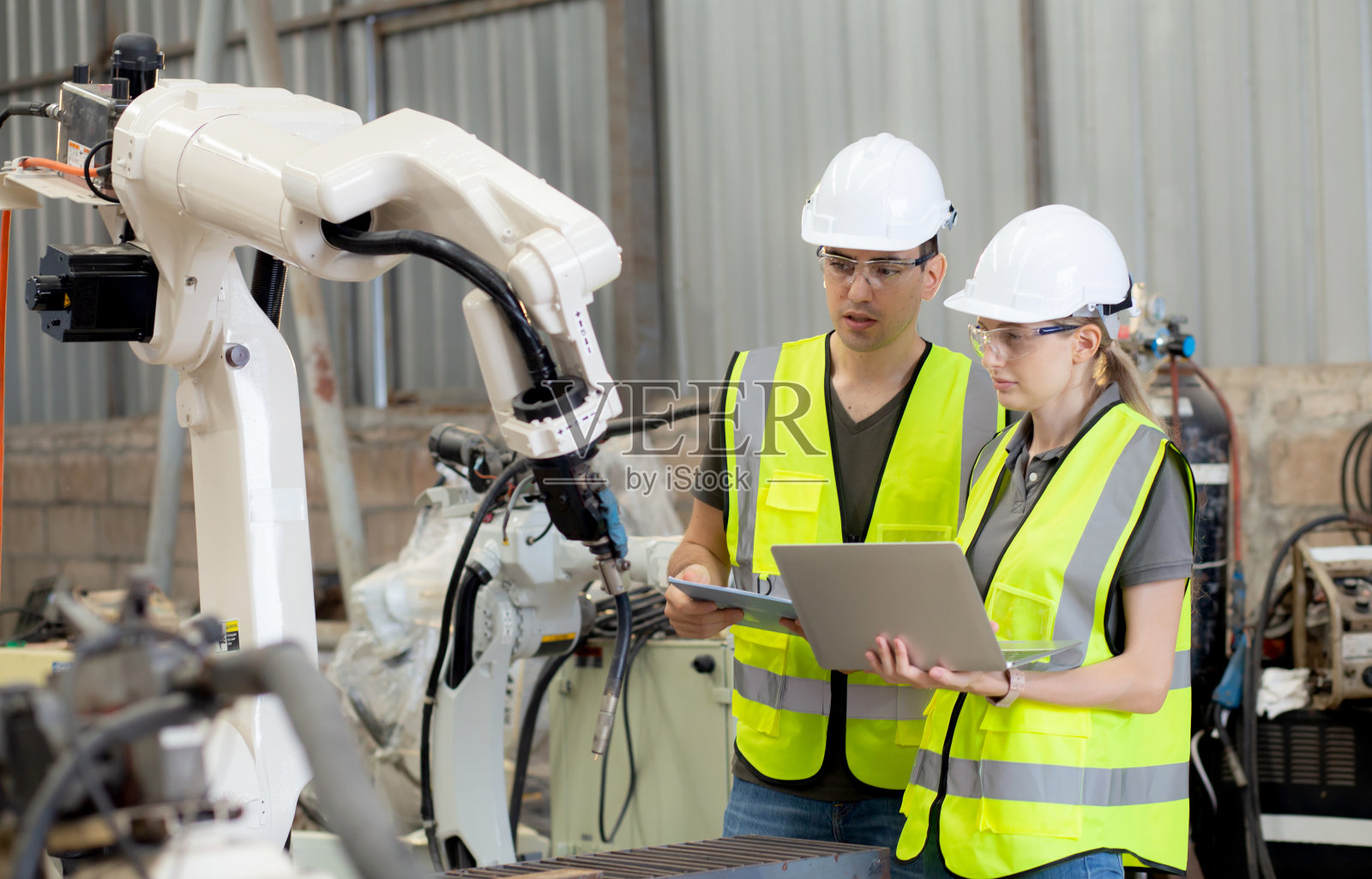 工程师男女在工厂谈论和解释机械臂技术智能和创新，开发机器机器人，人们检查机器电子，工业概念。照片摄影图片