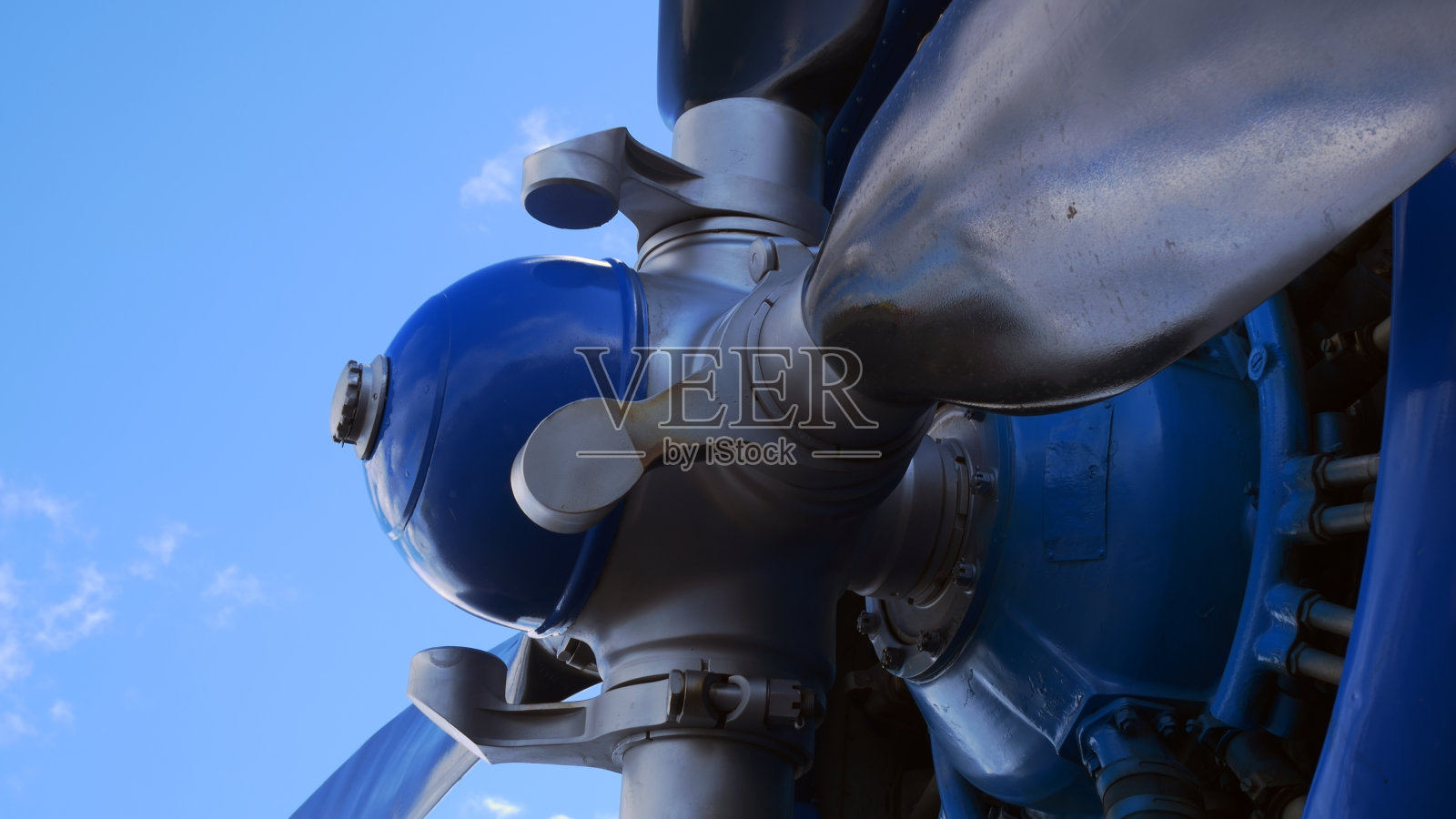 近距离拍摄，蓝色飞机的银色螺旋桨映衬着晴朗的天空。带螺旋桨和银色叶片的飞机涡轮。浅灰色的飞机发动机叶片。飞机螺旋桨发动机。空气动力飞机。照片摄影图片